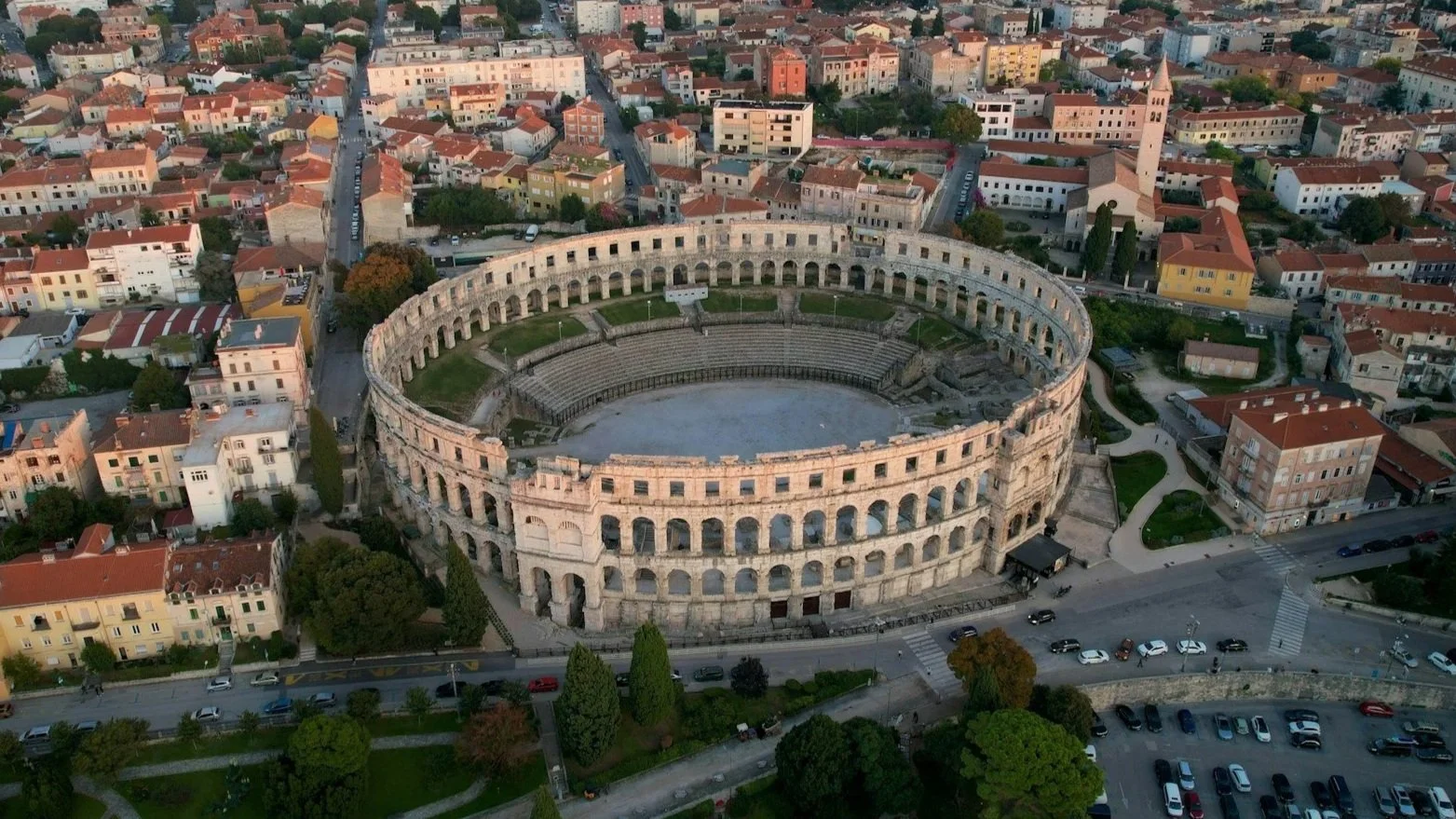 High-angle view of the Pula Arena, a well-preserved Roman amphitheater surrounded by the city of Pula.