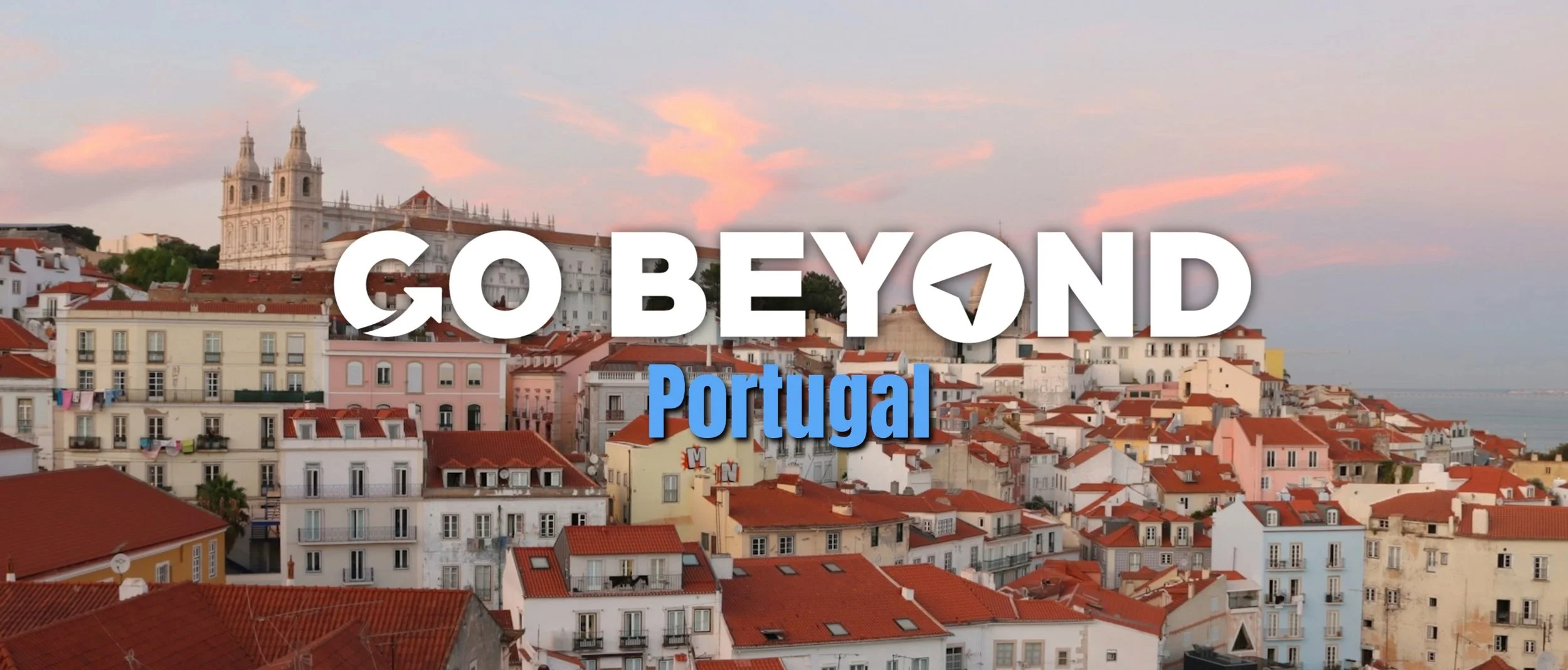 A sunset view over the red-roofed buildings of Lisbon with a white church in the background and "GO BEYOND Portugal" text overlaid.