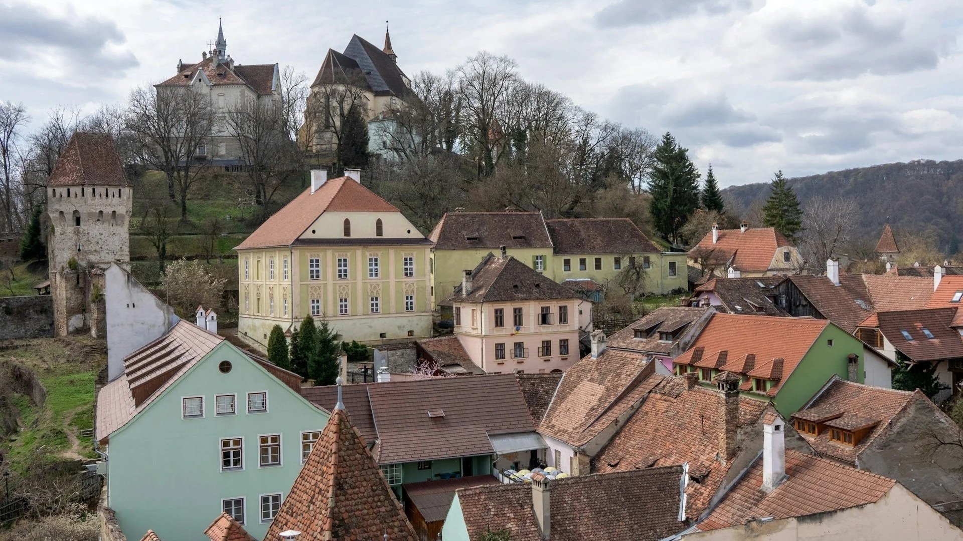 An elevated view of historic, colorful houses with terracotta roofs in the medieval citadel town of Sighișoara.