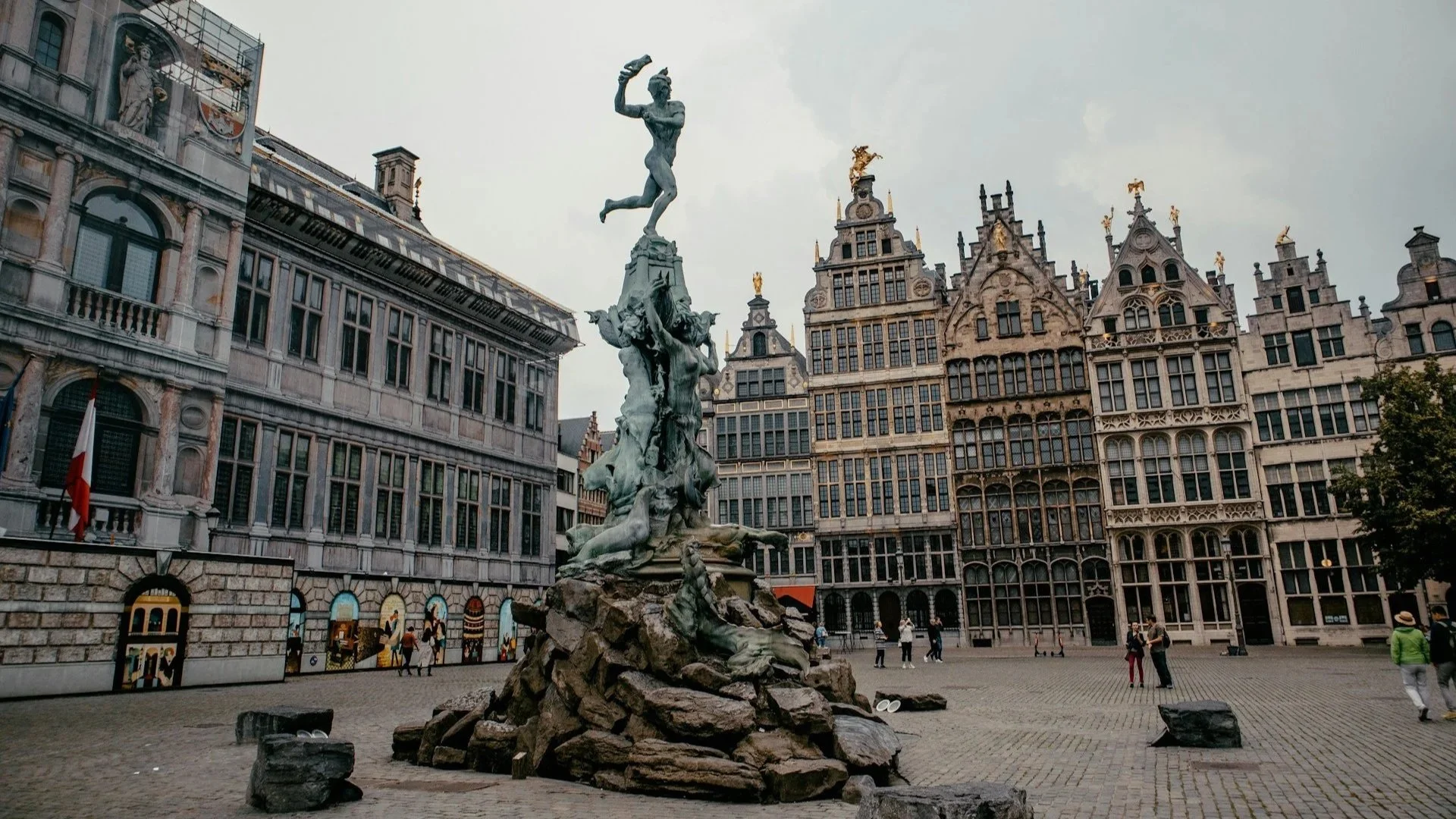 The Brabo Fountain statue standing in the Grote Markt square of Antwerp surrounded by traditional guildhalls.