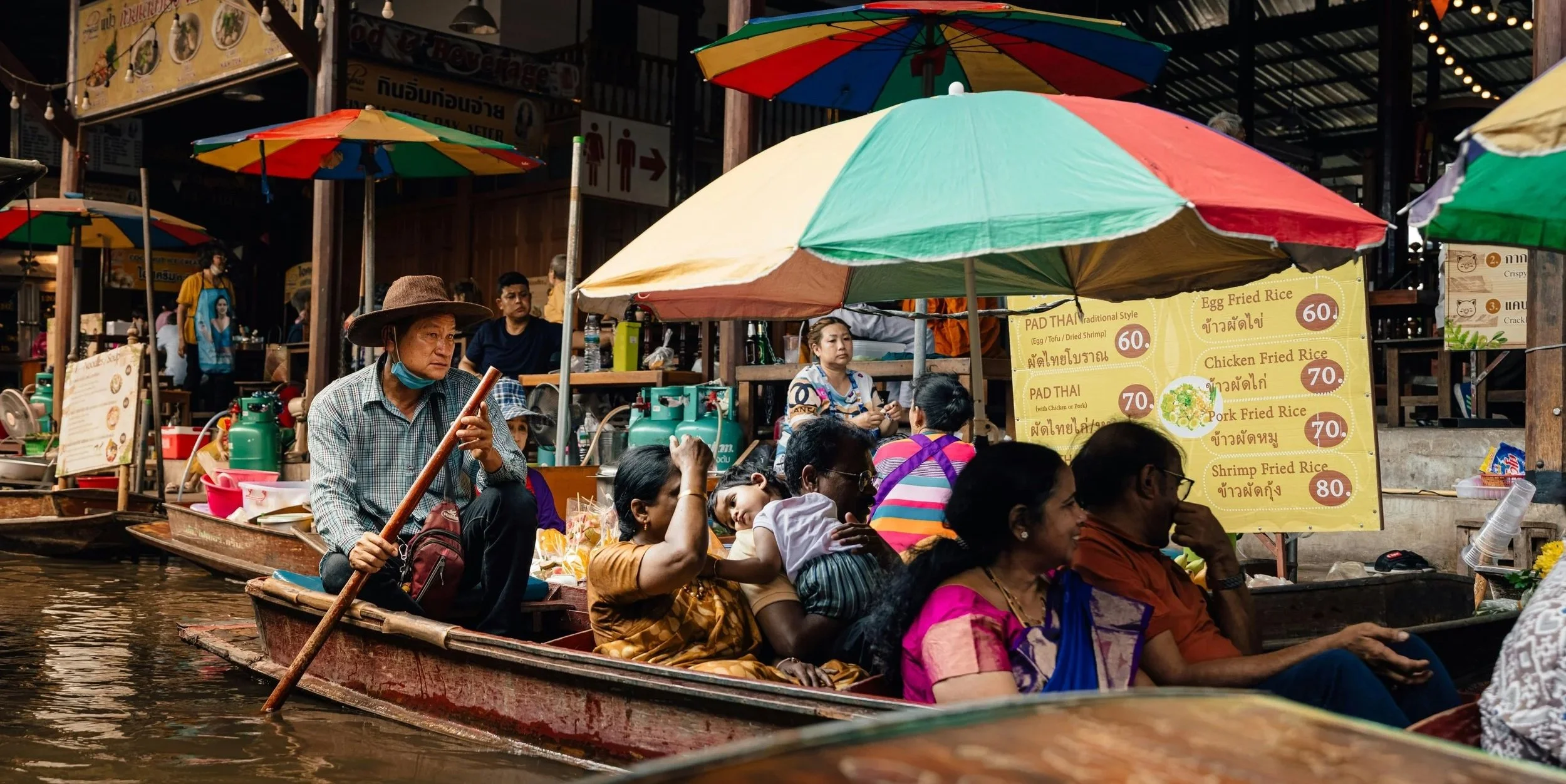 People in boats at a bustling floating market.
