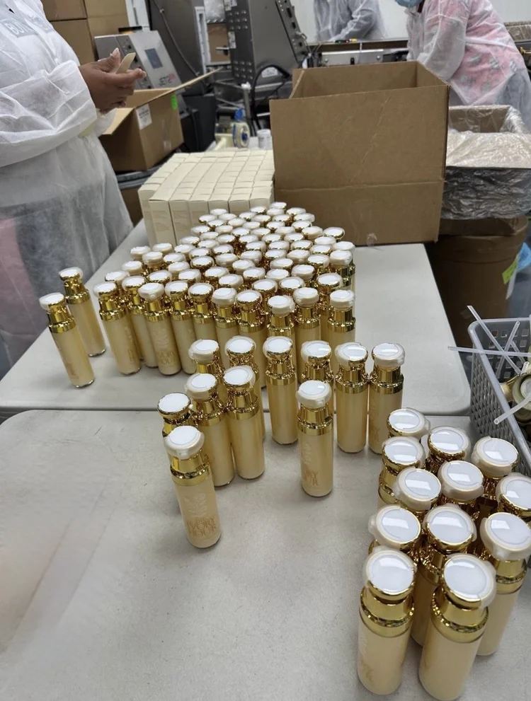 Gold airless bottles of a brightening serum on the packing table