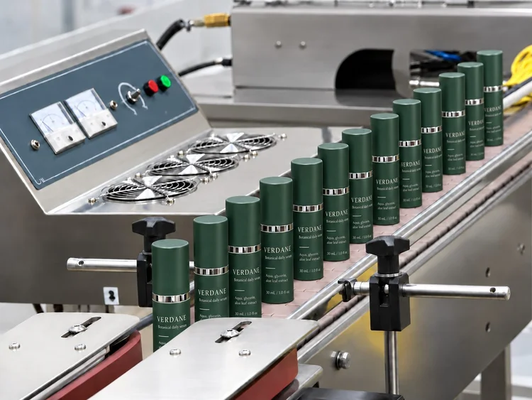 Green airless bottles moving along the filling line at the Vaulabs facility