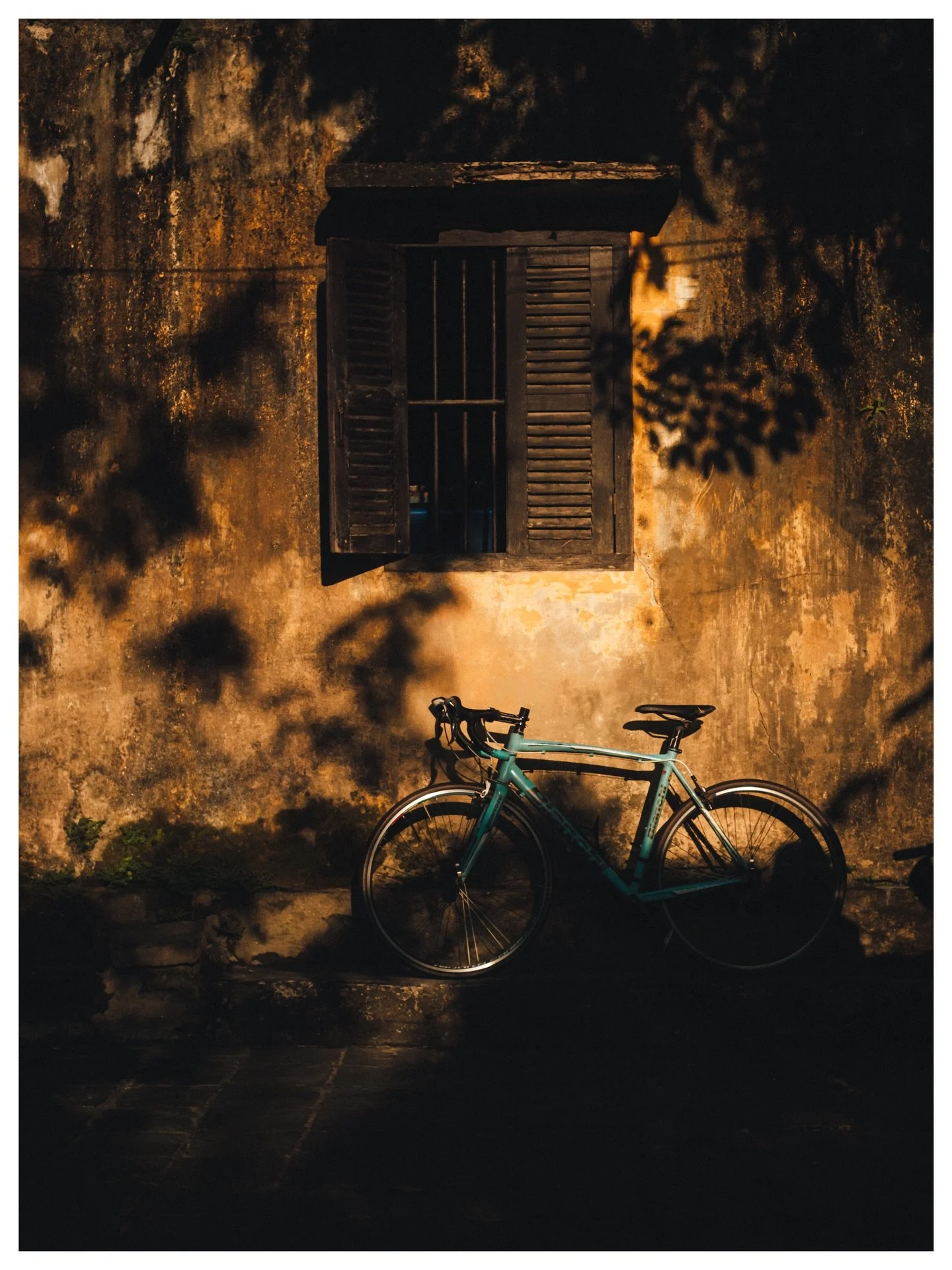 The Bike That Waited

FR :
Hoi An, heure dor&eacute;e. Un v&eacute;lo turquoise gar&eacute; contre un vieux mur. La peinture qui s&rsquo;&eacute;caille, l&rsquo;ombre qui commence &agrave; descendre, et cette lumi&egrave;re de fin de journ&eacute;e q