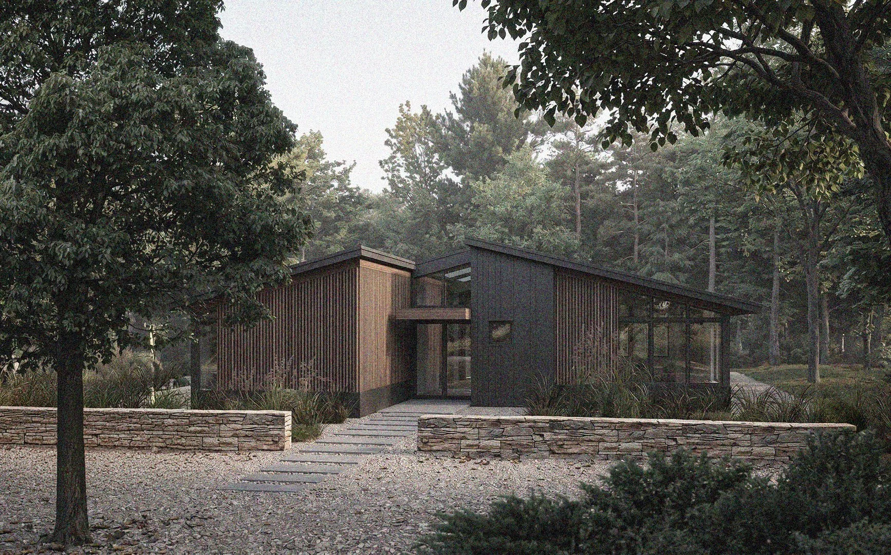 Modern house with black and wood exterior, situated amidst trees and greenery, with a stone fence in the foreground.