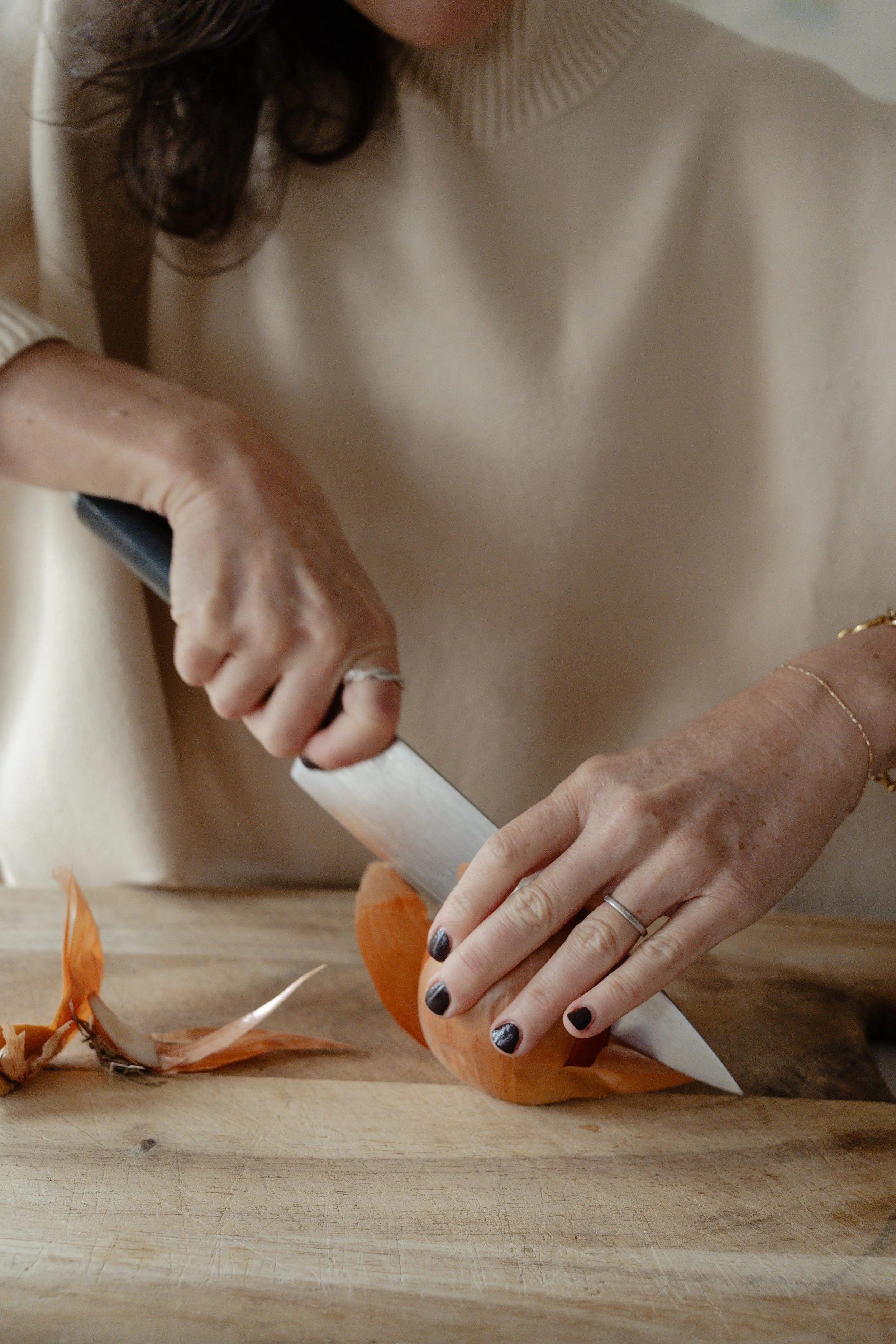 A close up photo of a woman chopping onions.