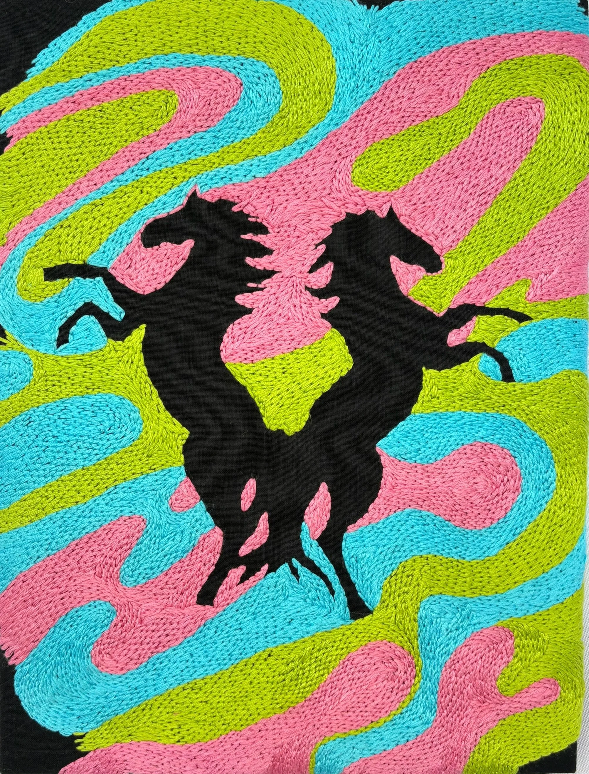Silhouette of two horses with an embroidered background of swirling colors in pink, blue, and green by Hannah Kennedy