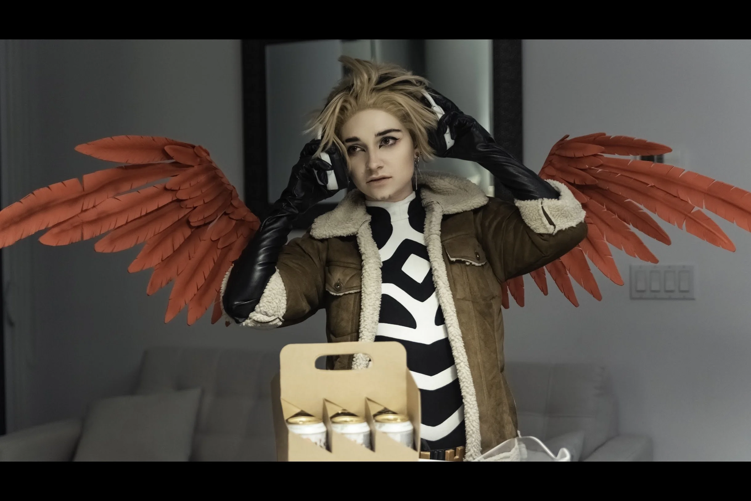 Hawks removing his headset and goggles, having set the six pack on the table.