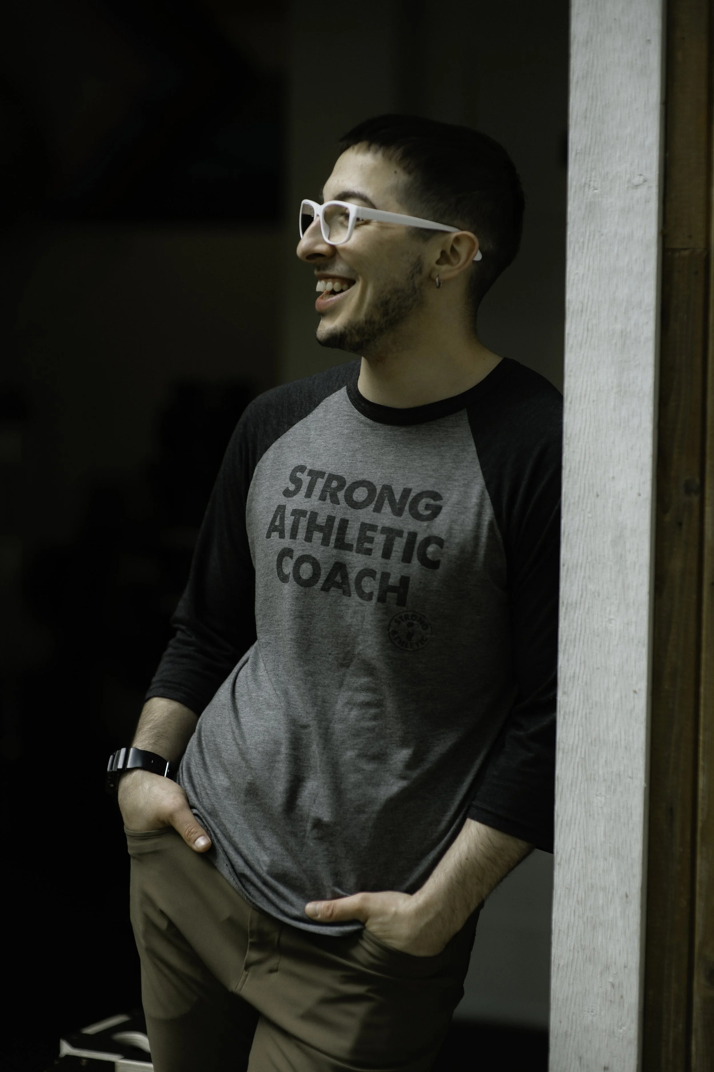 Dibs smilling warming wearing a shirt that say Strong Athletic Coach