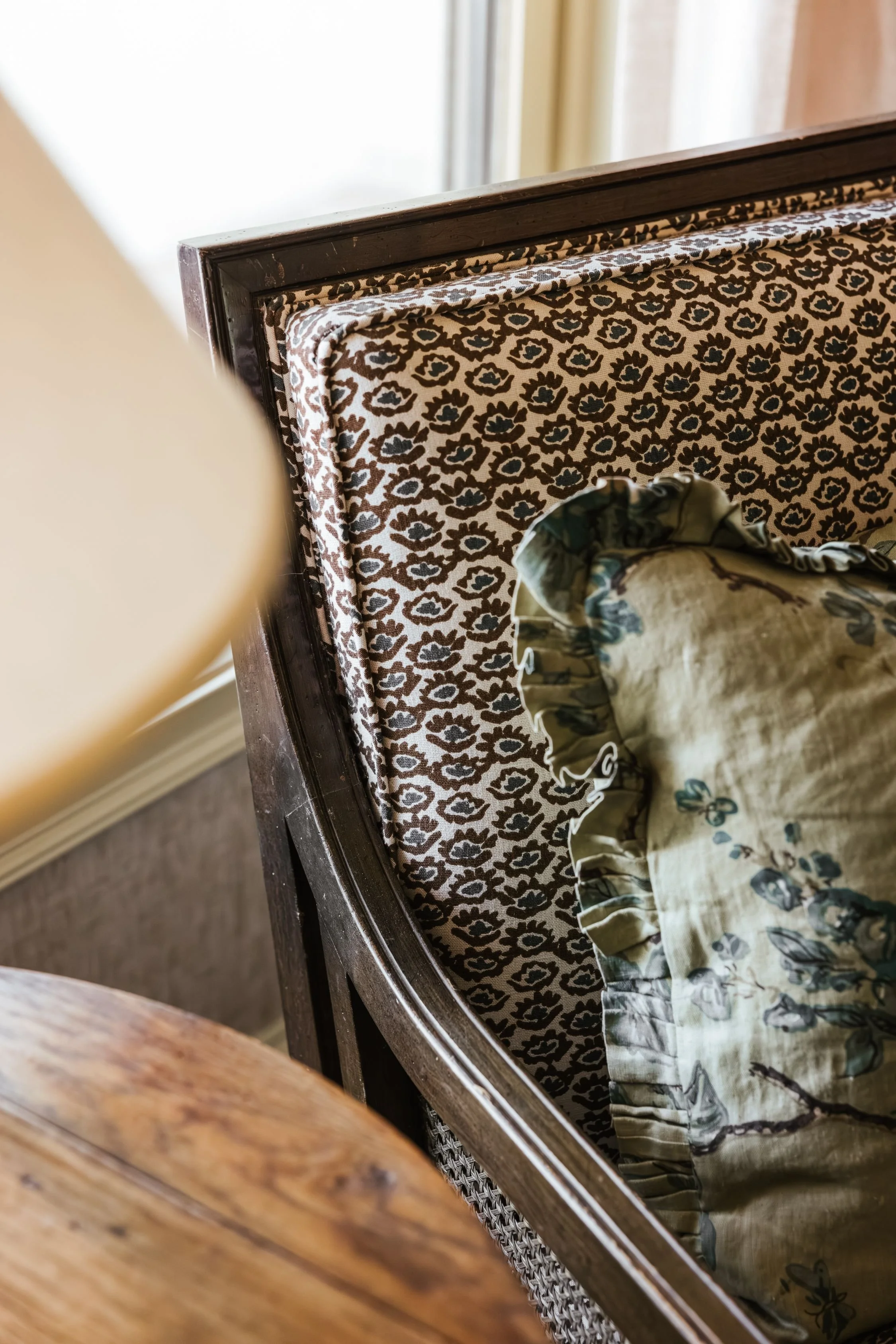 A corner of an upholstered armchair in the Lotus print.