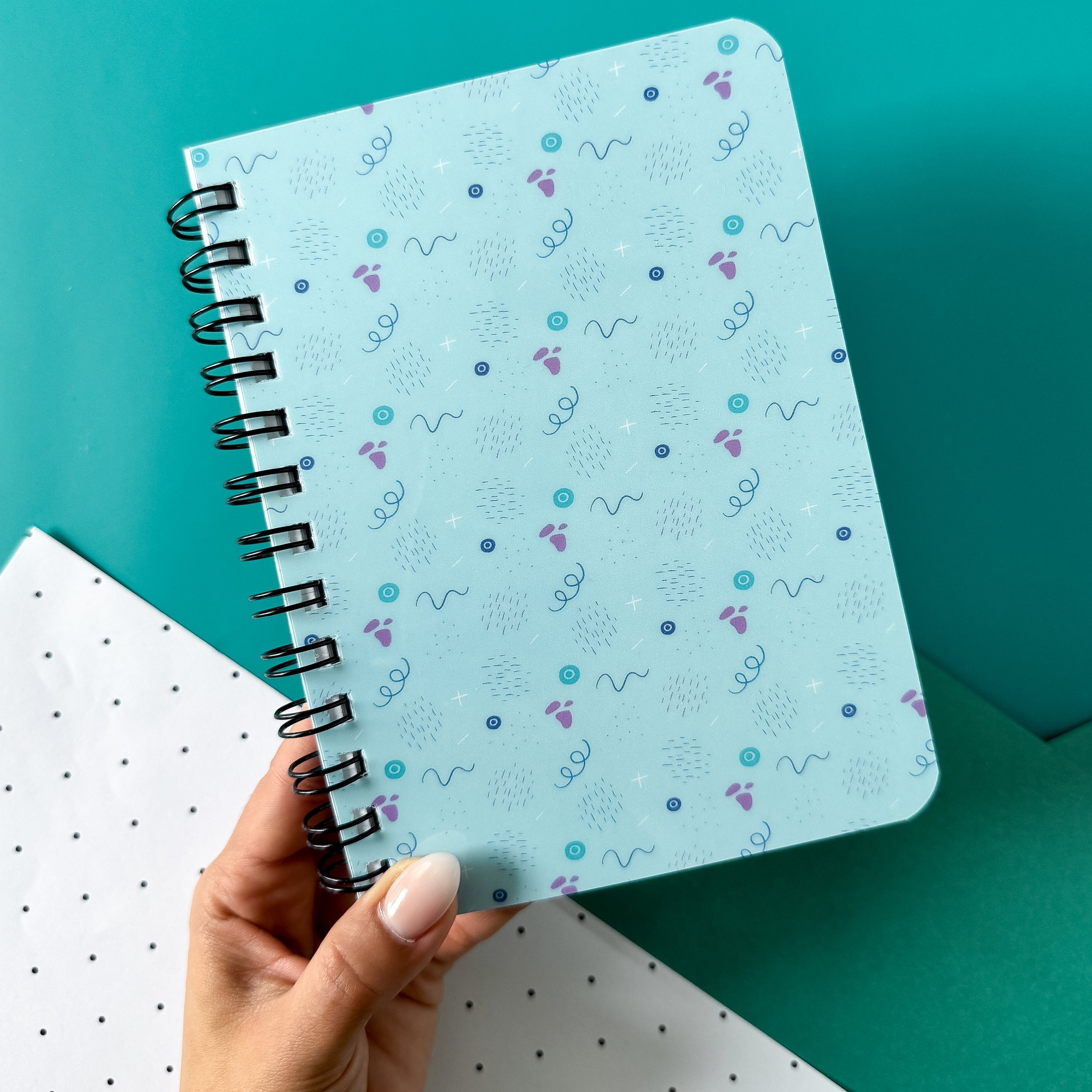 office supplies with spiral bound notebook with a pattern of lines and abstract shapes