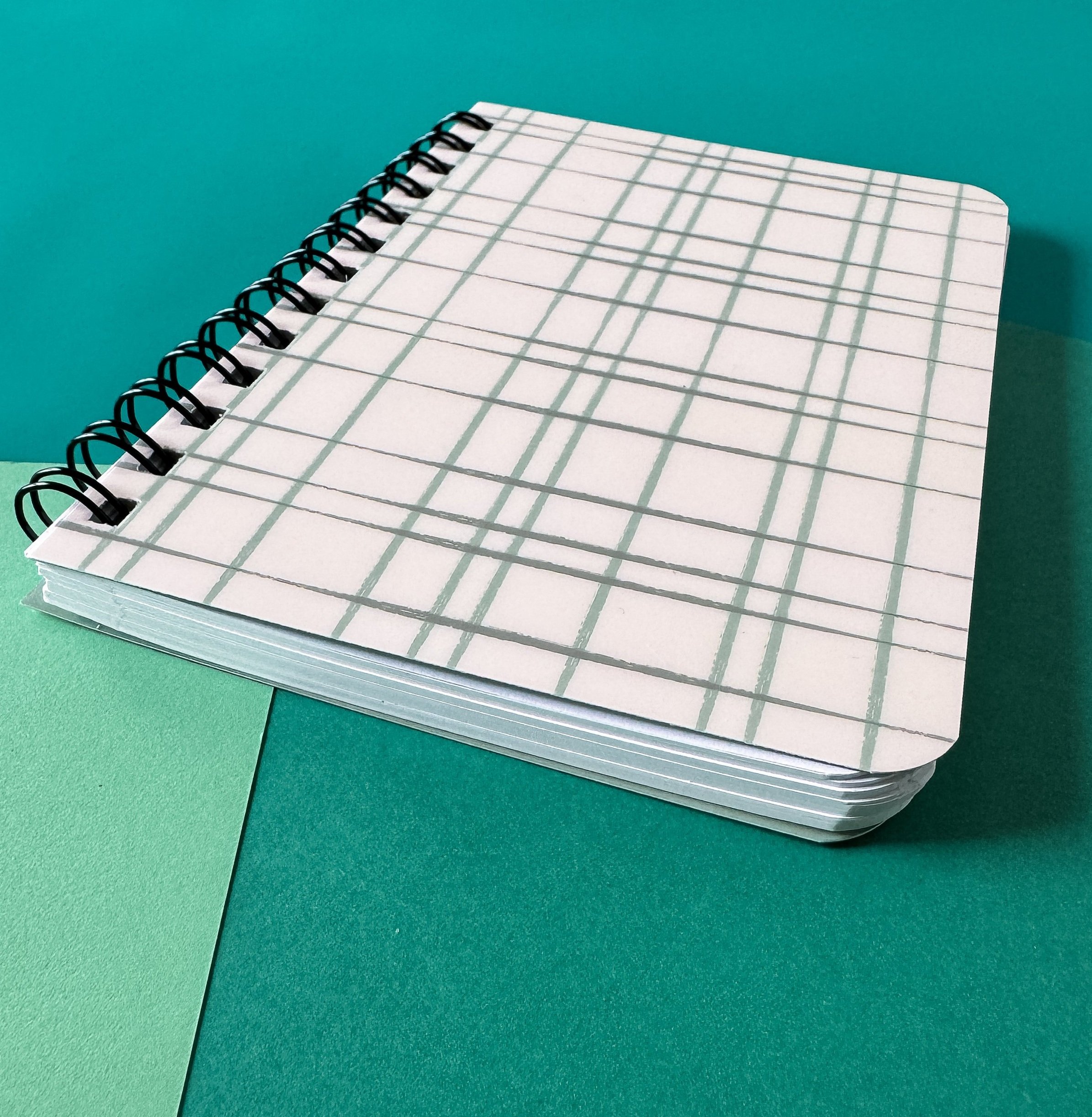 spiral bound notebook with lines pages and shiny cover with hand drawn line pattern close up