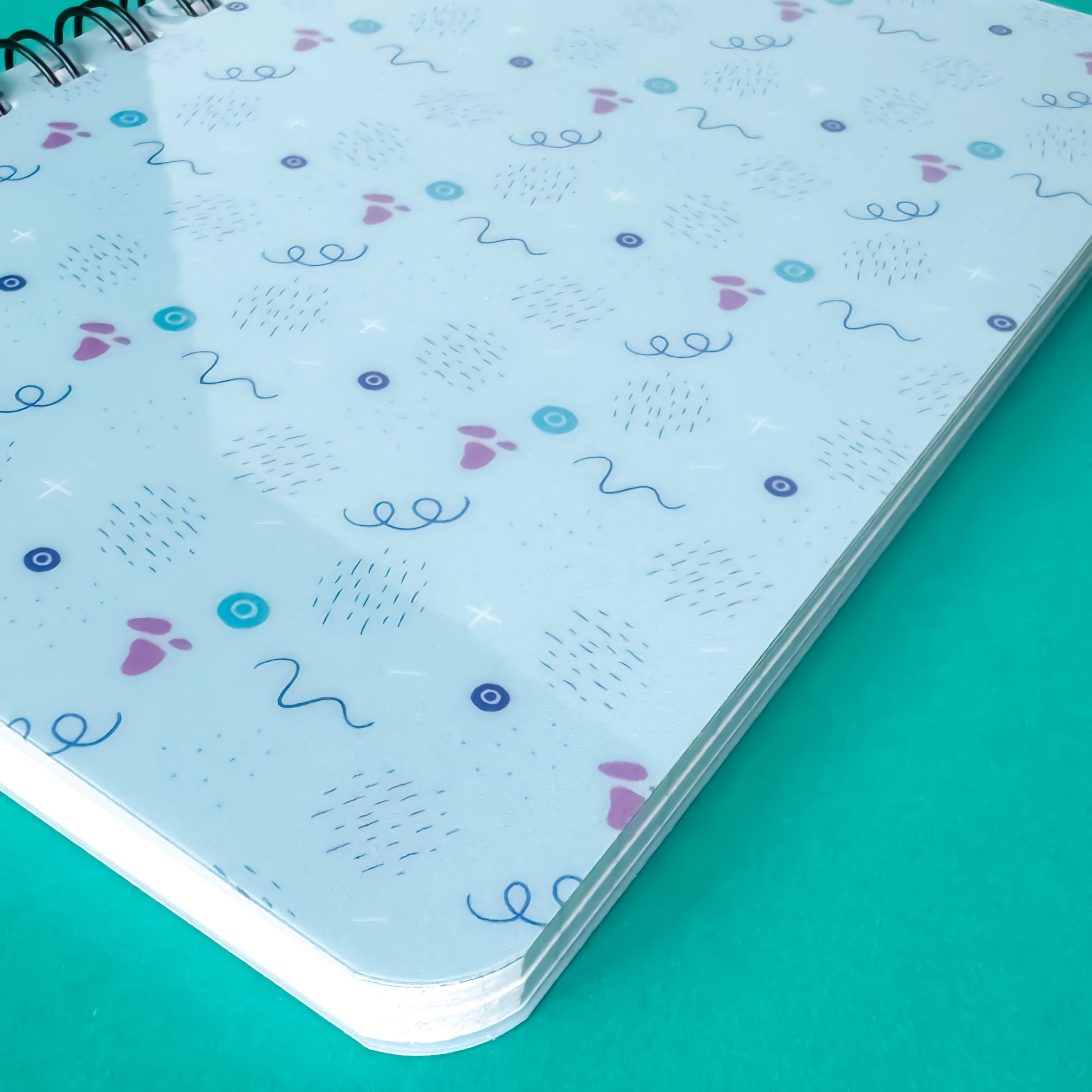 office supplies with spiral bound notebook with a pattern of lines and abstract shapes