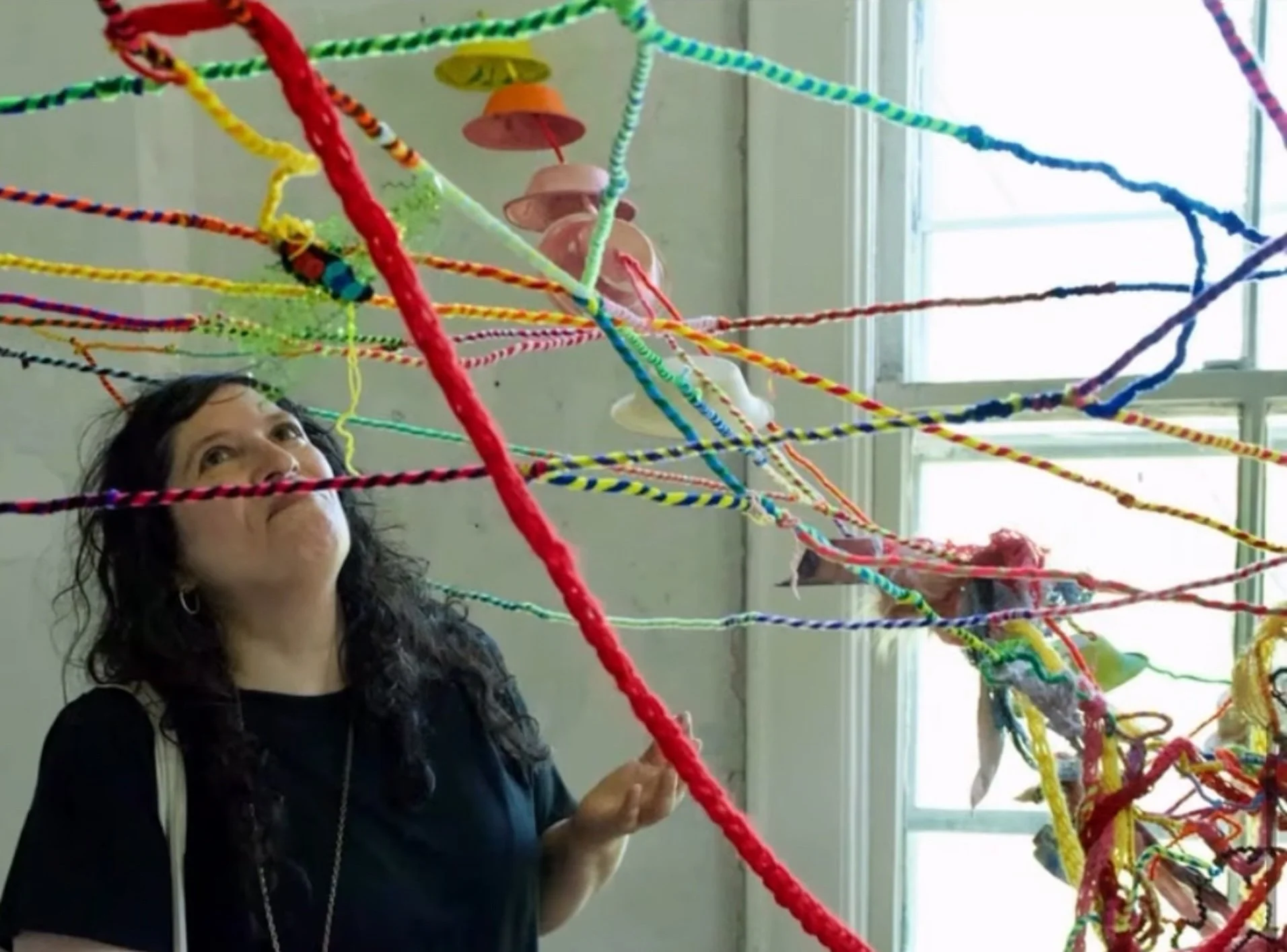 Yasmeen Abdallah is creating her installation at Governors Island using colorful, elaborate yarn and found materials to weave a web of connecting lines that can serve as a metaphor for growth, language, energy, and communication.