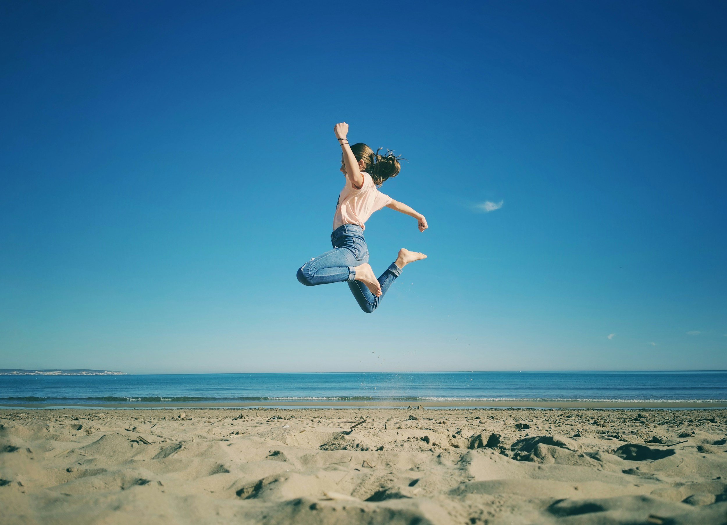 A woman jumping on the beach
