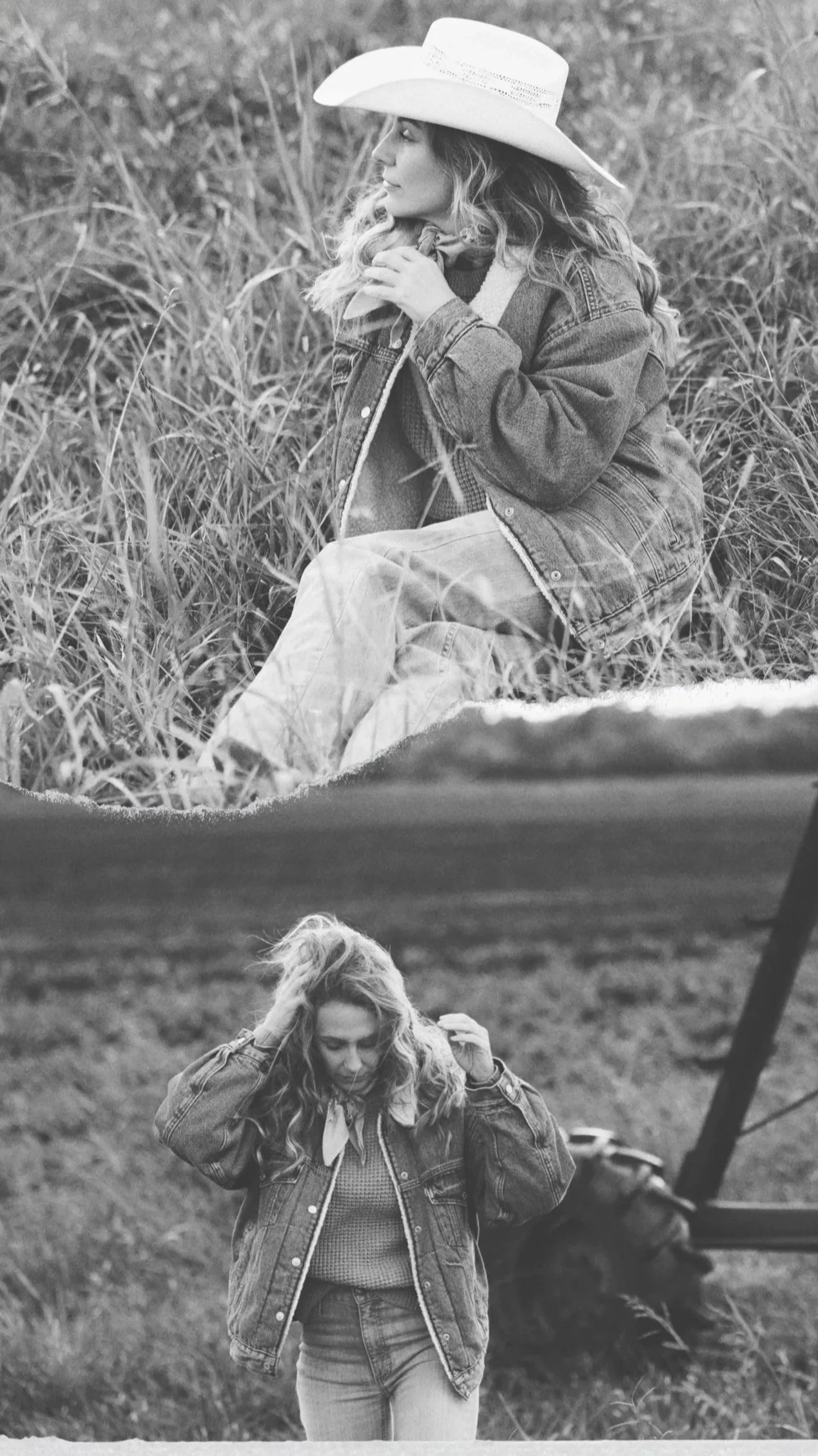 A woman with curly hair, wearing a denim jacket and jeans, sitting on grass behind a tent. She is adjusting her hair with her right hand.