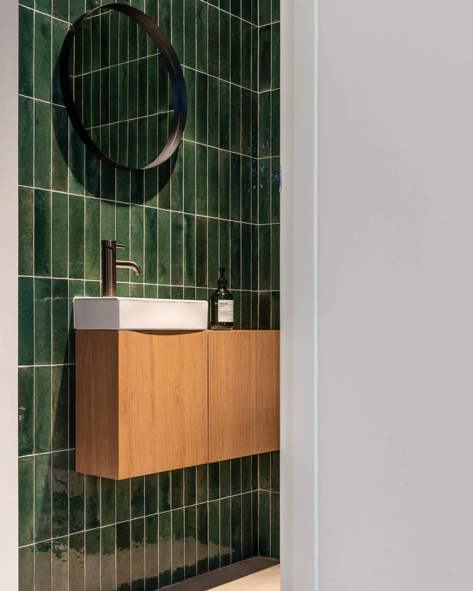 Interieurfotografie van een toiletruimte met de focus op een op maat gemaakt wastafelmeubel door een interieurbouwer, gefotografeerd met oog voor materiaal en detail.