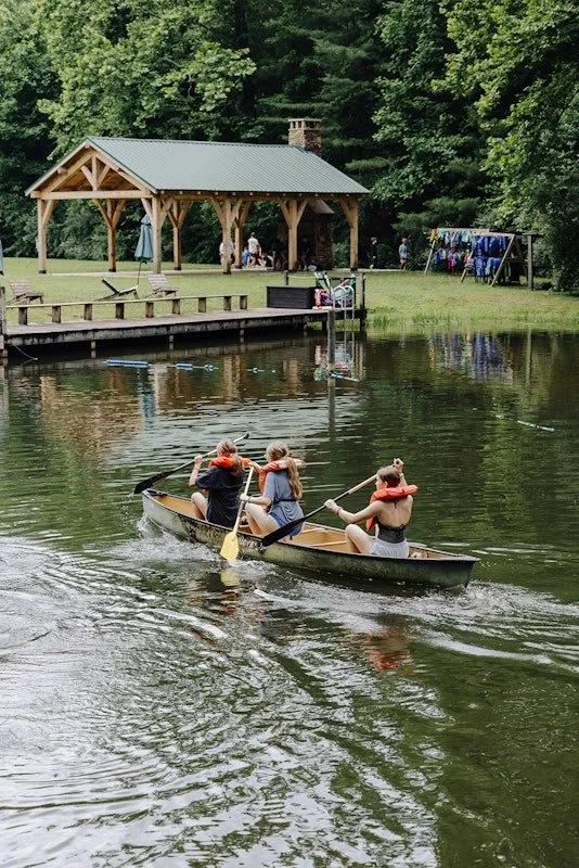 campers smiling and raising hands at christian summer camp