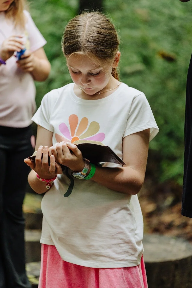 Camper reading her bible in her cabin at christian summer camp