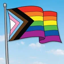 Flag with a rainbow pride design on a blue sky background.