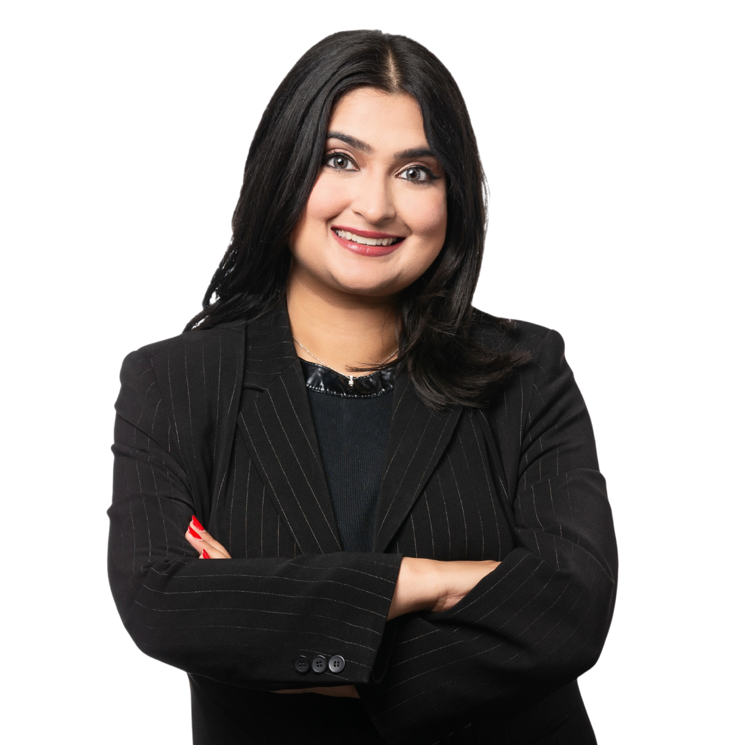 A confident woman with dark hair and makeup, wearing a black striped blazer with arms crossed, smiling at the camera.