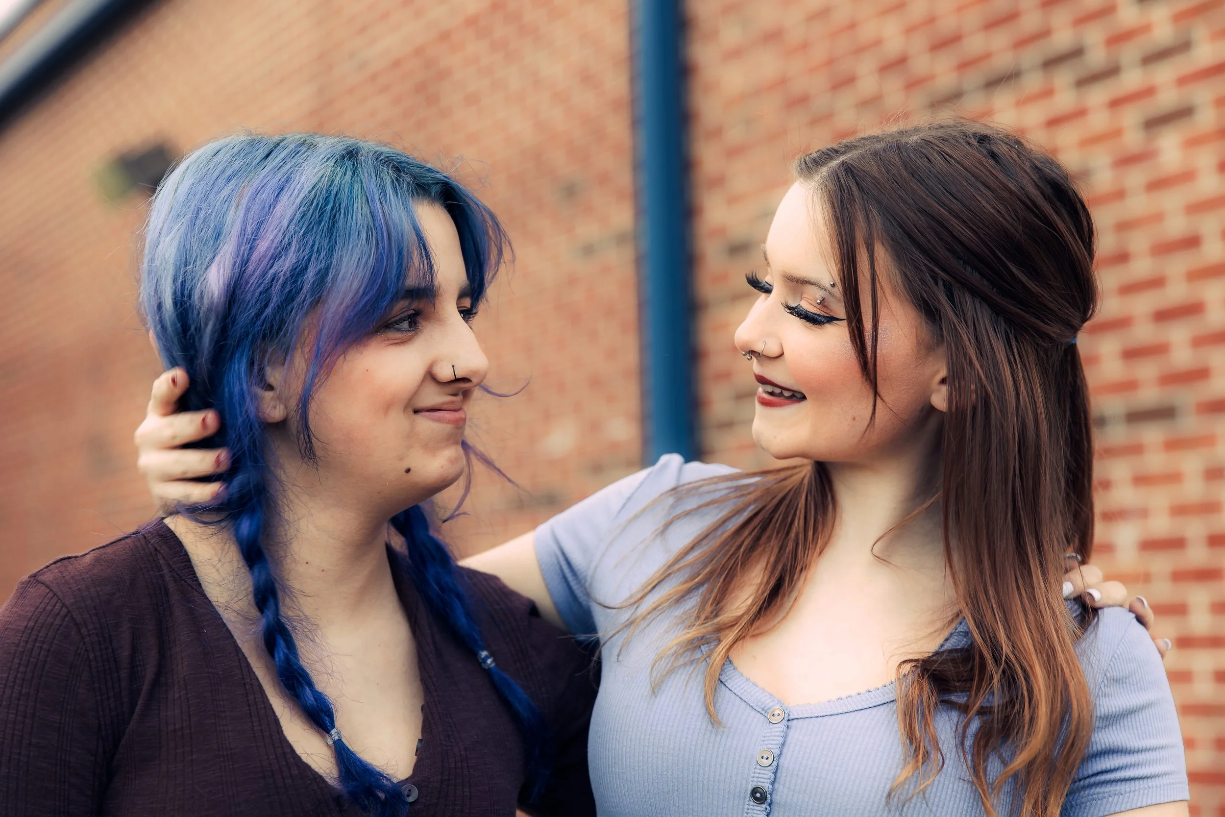 Two friends share a quiet moment outside the school.