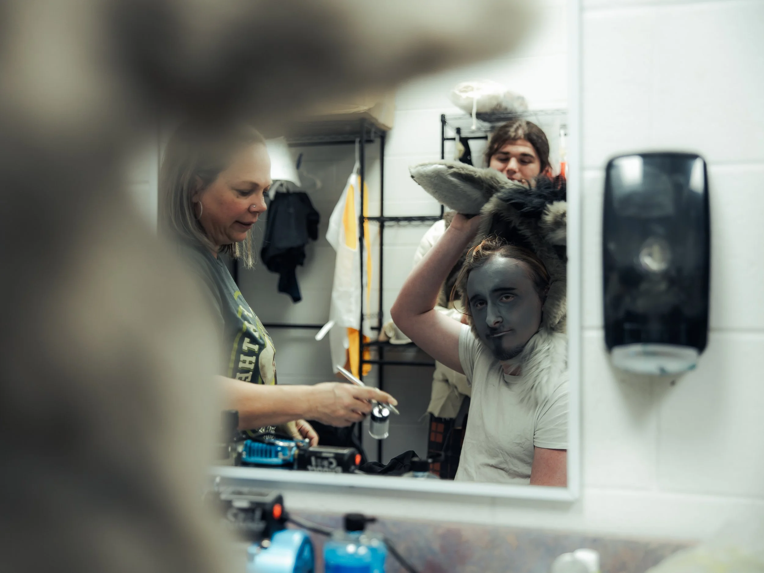 Getting ready together, seen through a backstage mirror.
