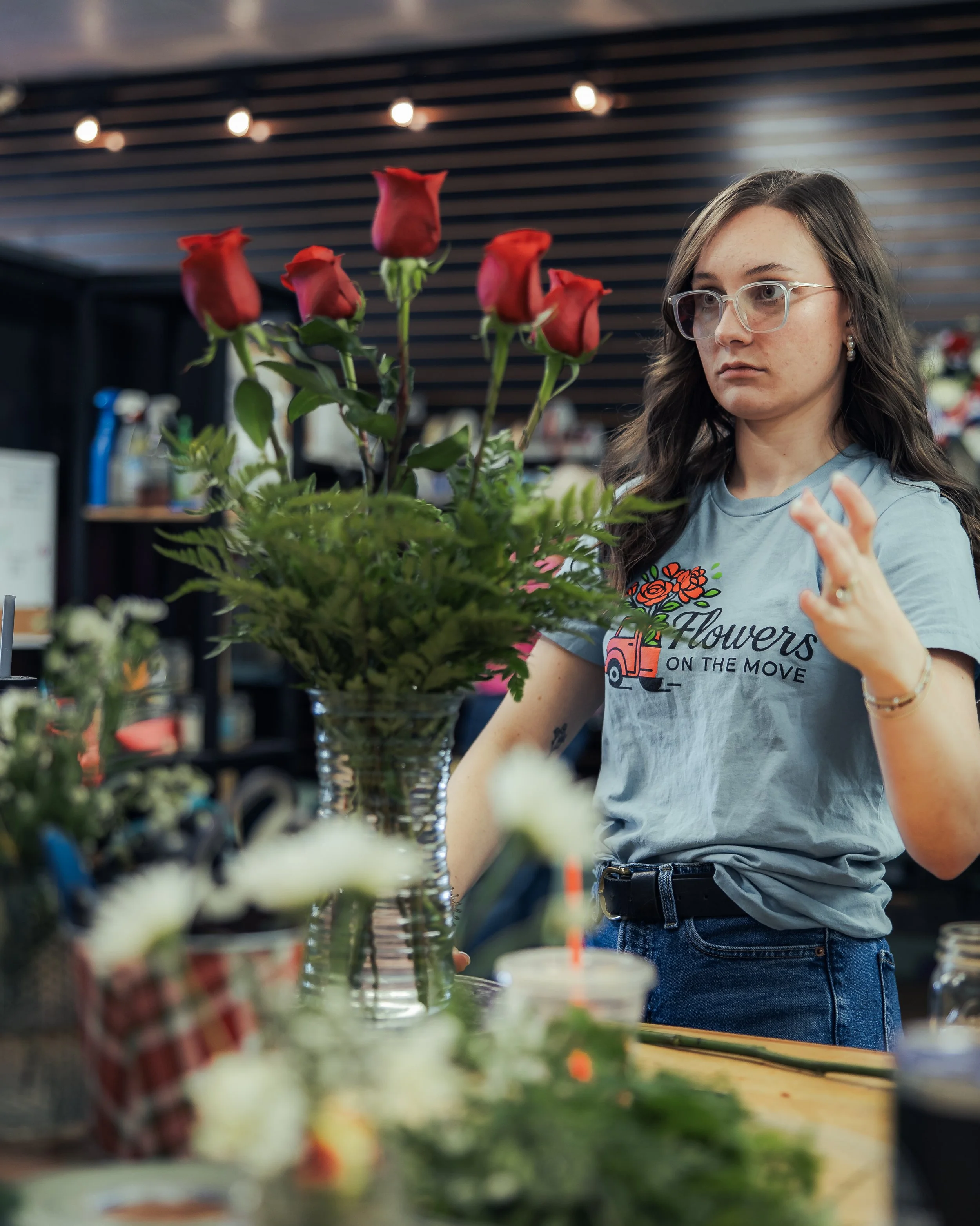 A florist arranges red roses at Flowers on the Move.