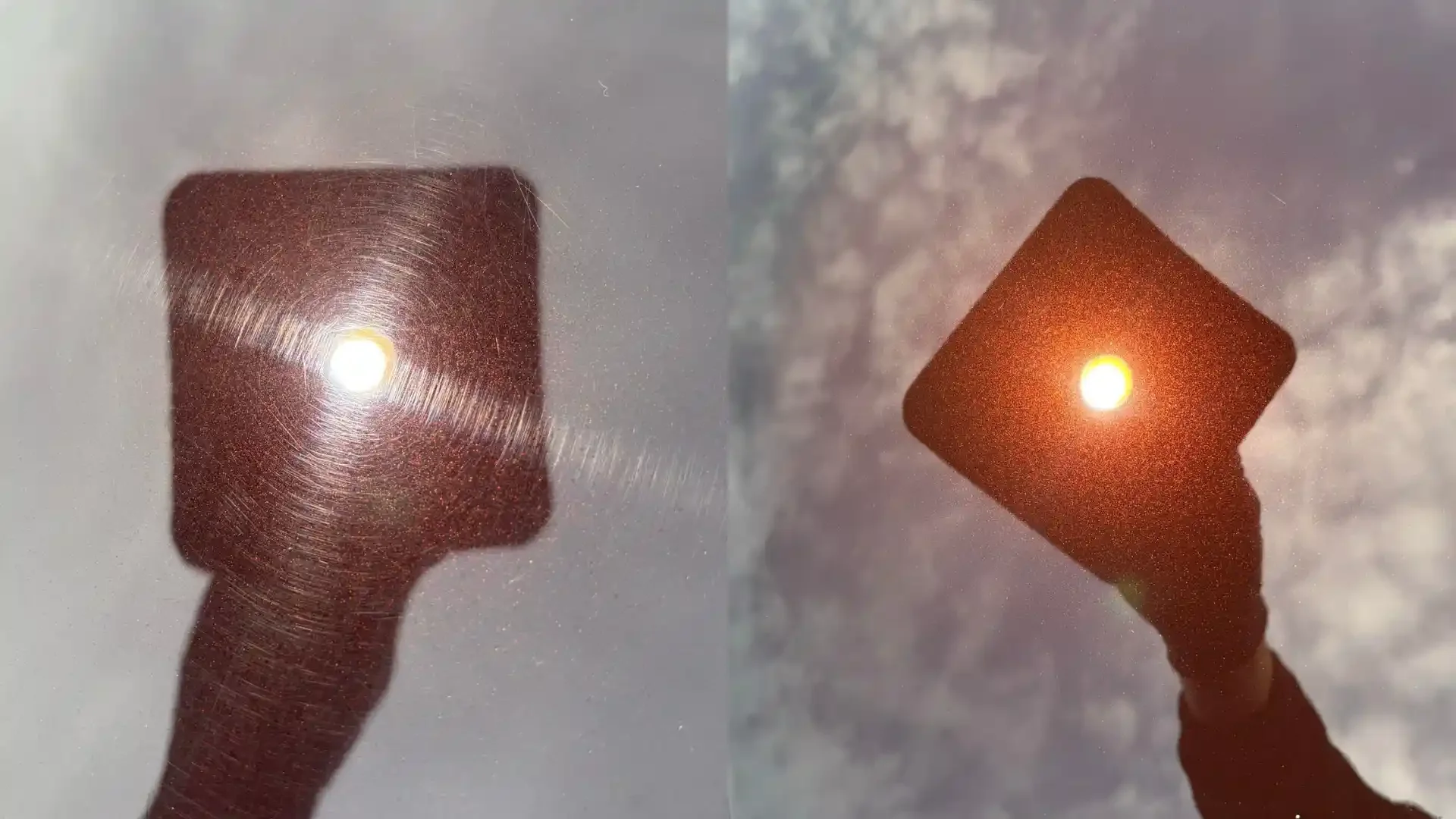 A person's hand holding a square-shaped mirror reflecting the sunlight, with the sky and clouds in the background.
