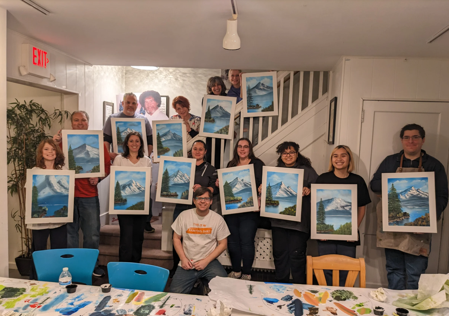 Group holding landscape paintings after an art class.