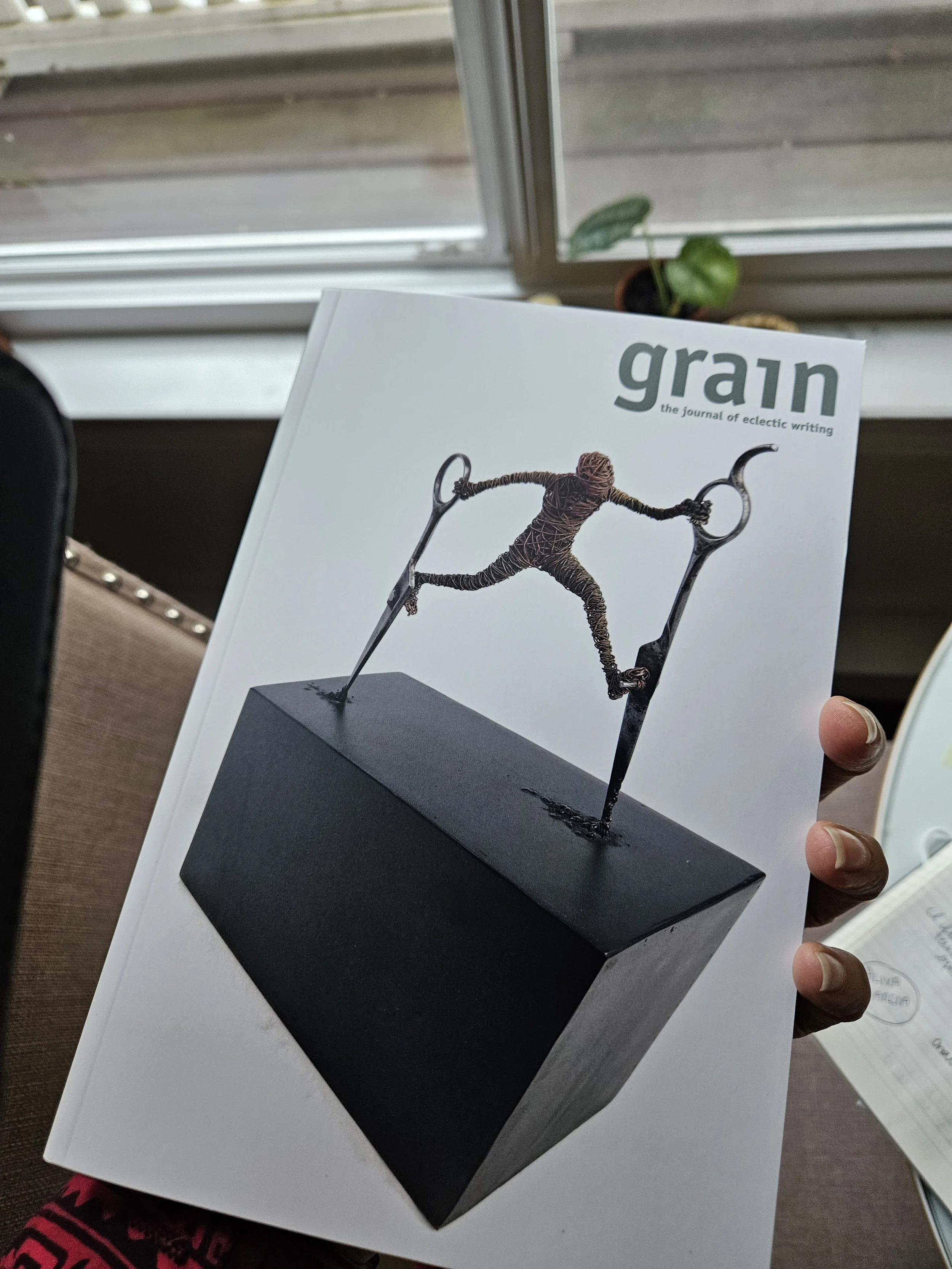 The logo for 'grain,' a journal of eclectic writing, with the word 'grain' in large, bold, orange letters and the tagline 'the journal of eclectic writing' underneath in smaller orange font.