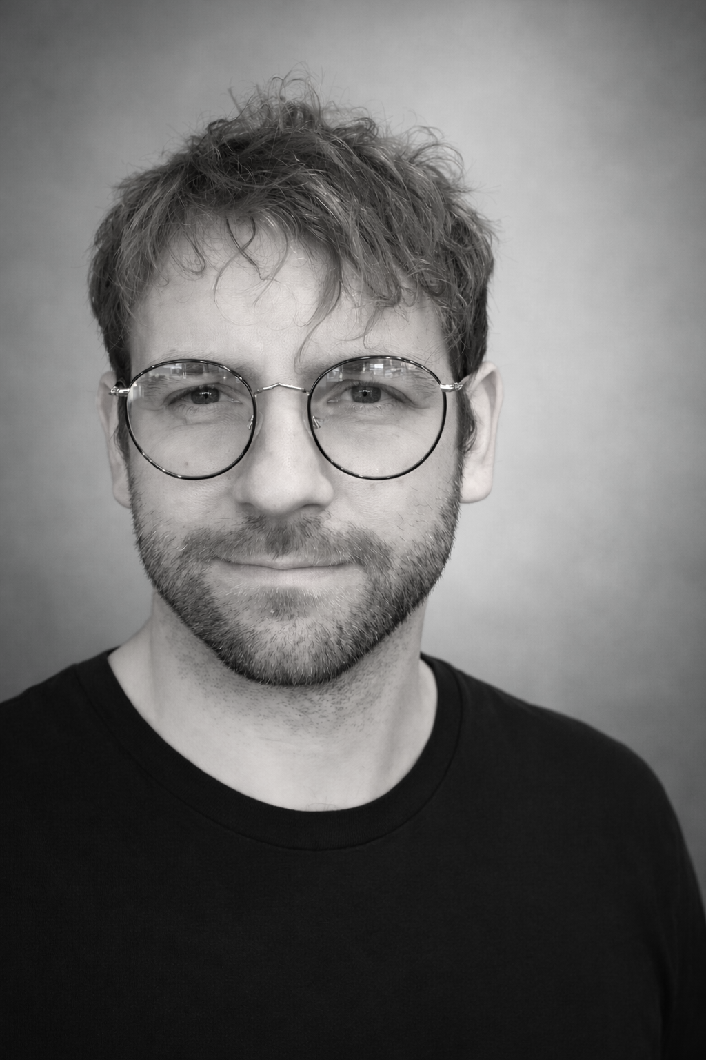 Black and white portrait of a man in a white shirt and bow tie.