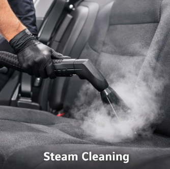 Person wearing black gloves using a steam cleaner on car seats with steam visible, labeled 'Steam Cleaning'.