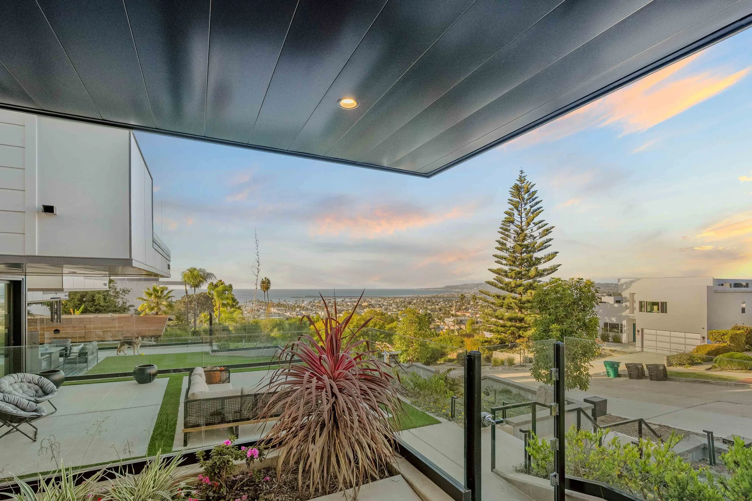 Sunset balcony view overlooking yard and ocean — luxury San Diego real estate photography by Magana Productions.
