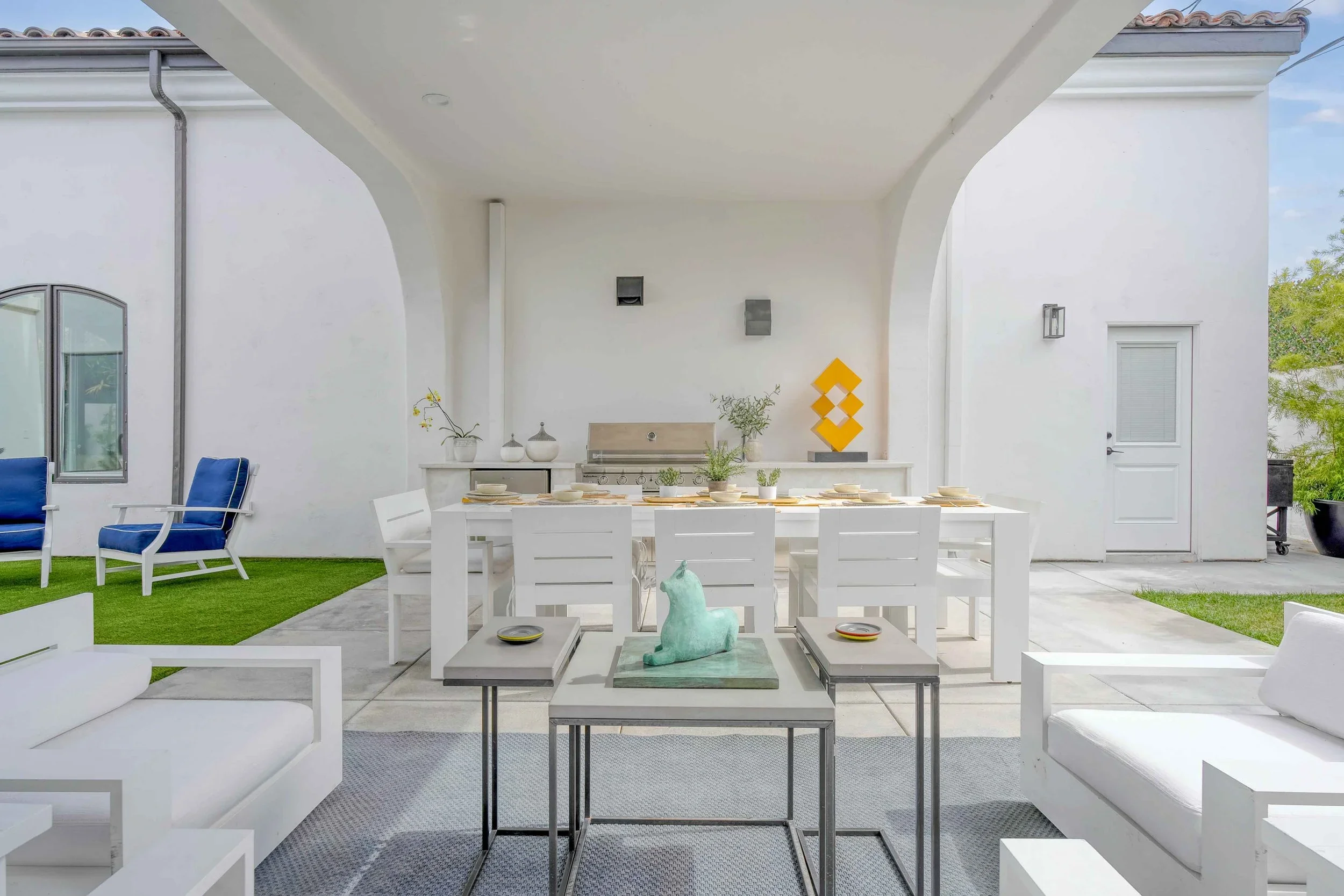Outdoor patio setup with white furniture and décor — daylight real estate photo by Magana Productions in San Diego.
