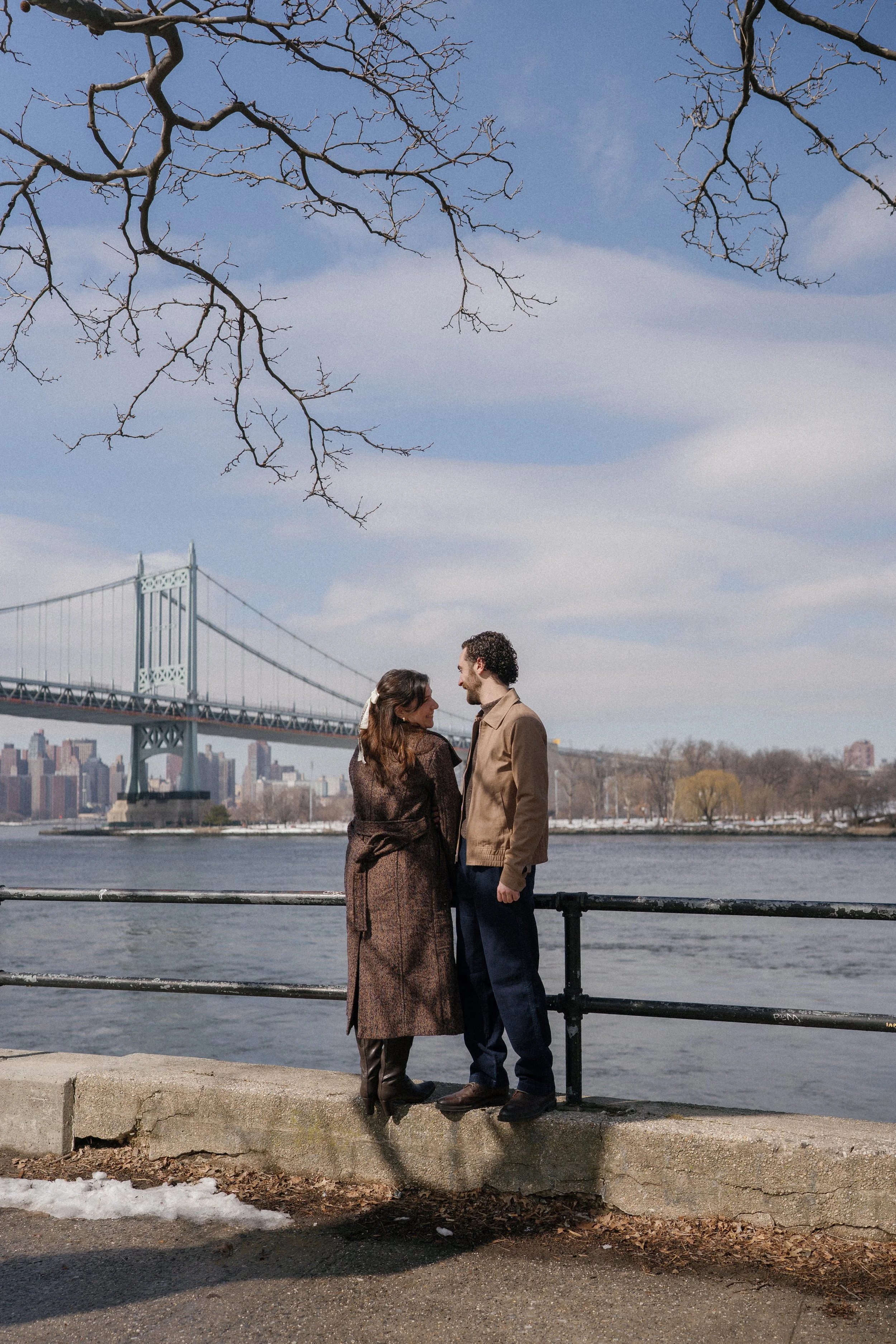 Couple standing in front of Astoria Park waterfront