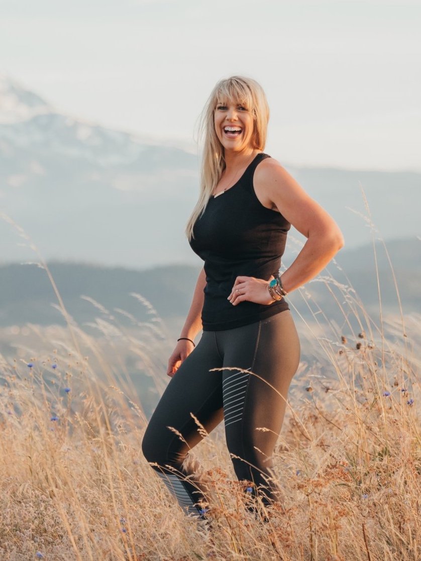 Coach Laura poses with Mount Hood behind her, smiling at camera