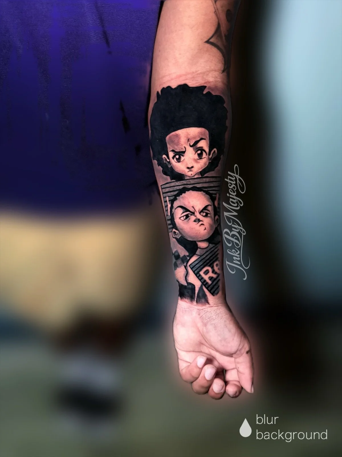 Tattoo of two animated characters with serious expressions on a person's forearm, with the text 'Ink By Magically' and a small droplet icon labeled 'blur background'.