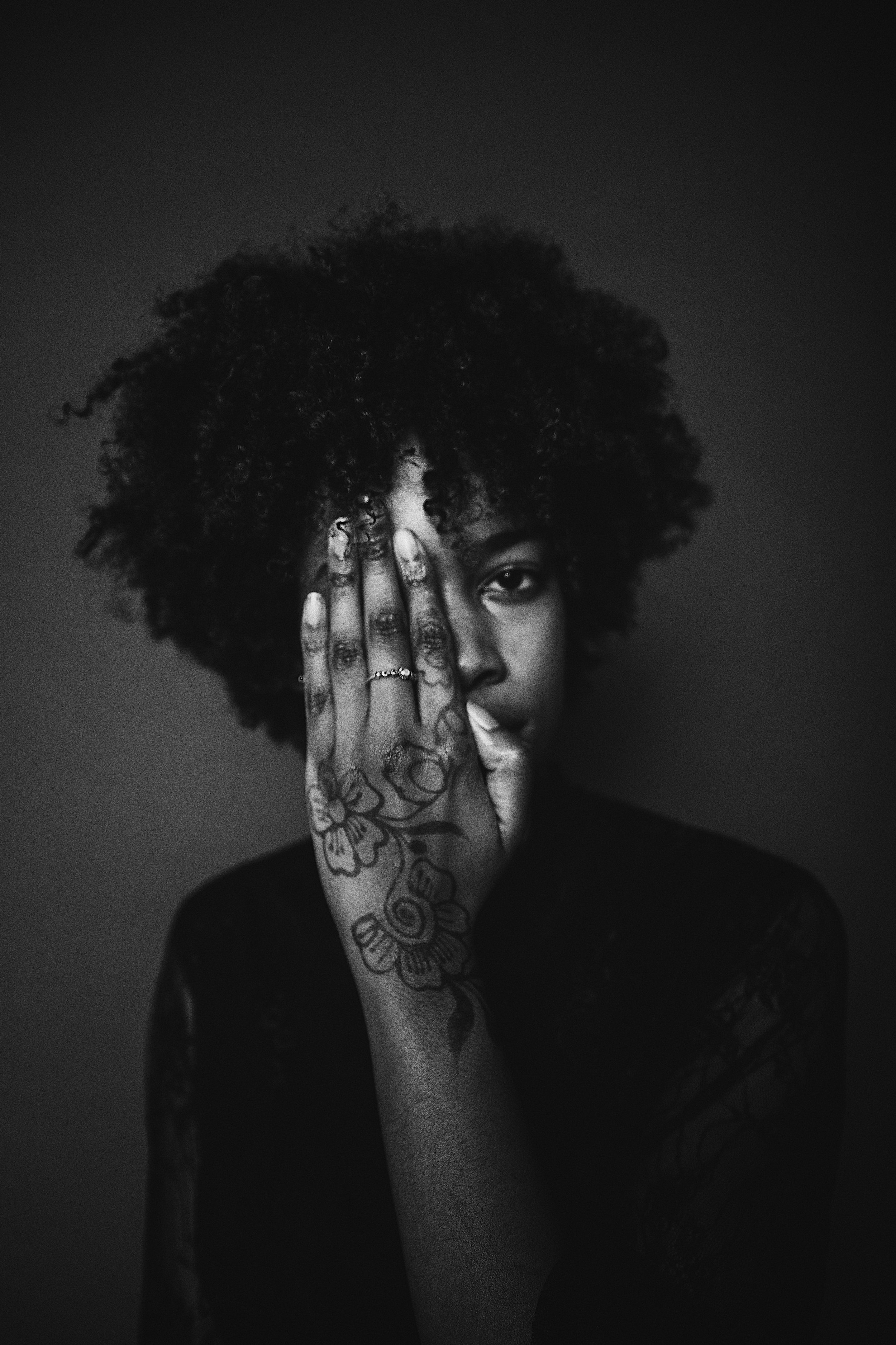 woman with black afro hair tattoo her hand
