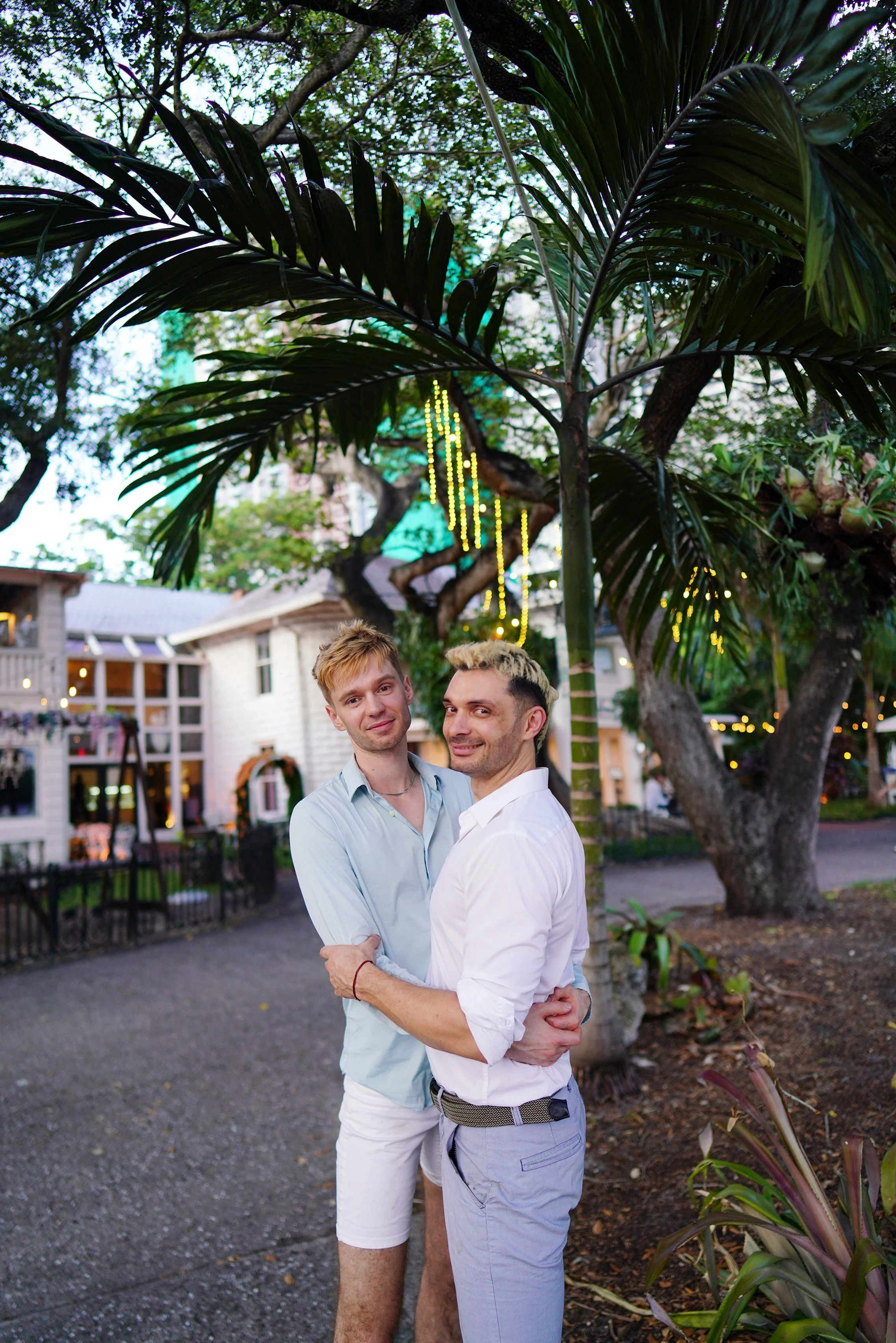 Candid wedding portrait of a gay couple laughing along a scenic river walkway, taken by a luxury photographer based in San Francisco.