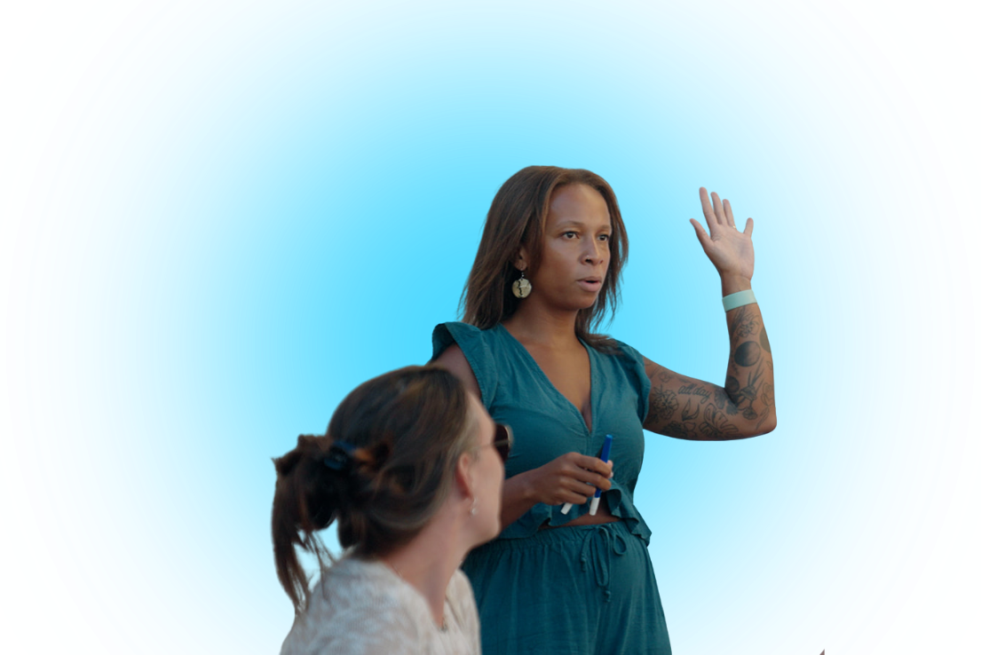 A woman in a blue suit raising her hand with a woman with sunglasses looking up to her