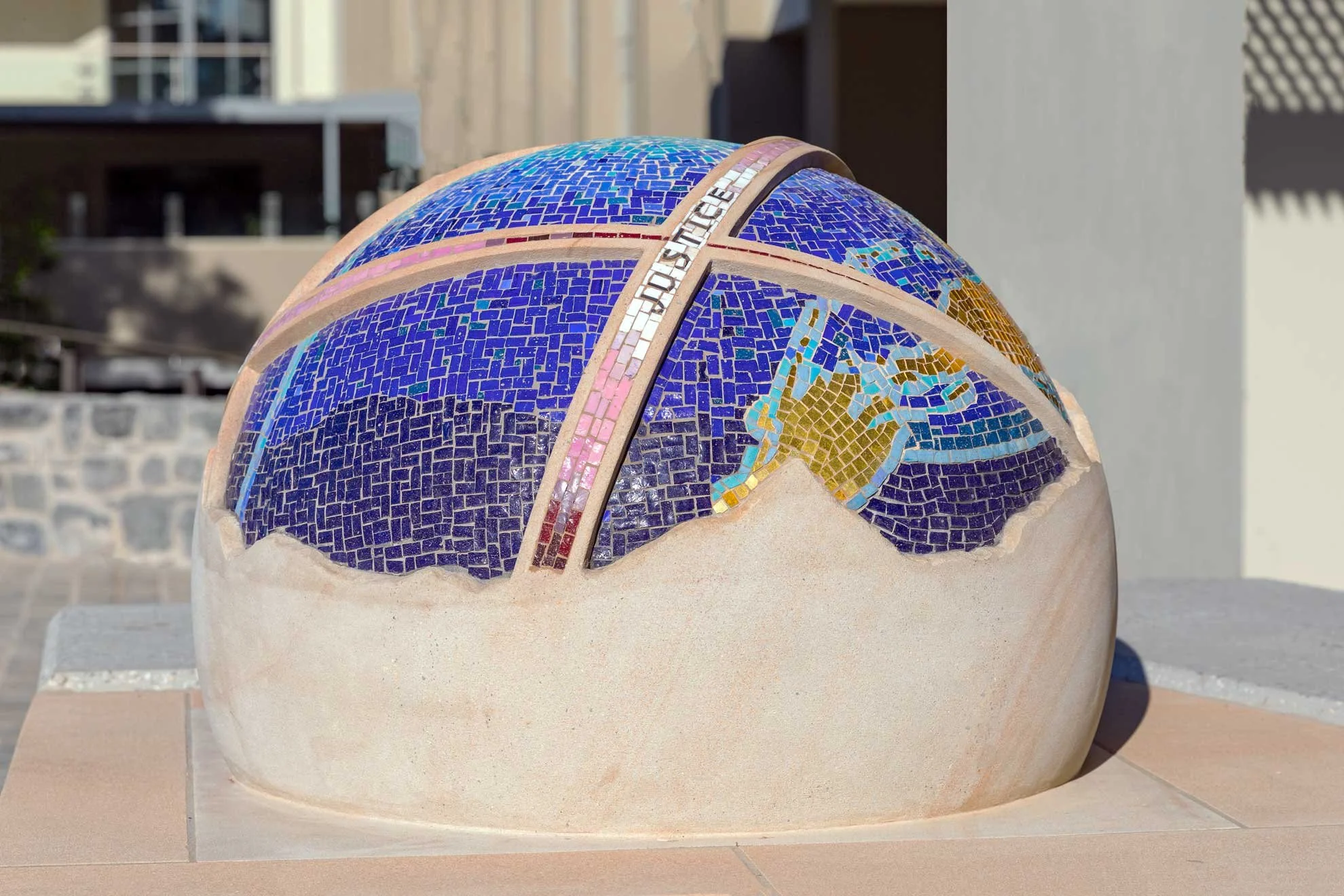 The St Rita's College Trinity Centre greets visitors with a stunning hand-carved sandstone sculpture of the Earth, adorned with Orsoni smalti and gold leaf tesserae. 