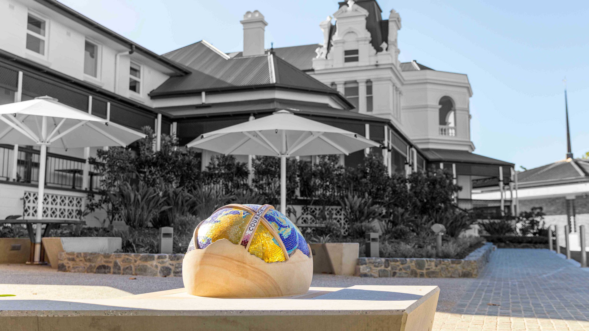 The St Rita's College Trinity Centre greets visitors with a stunning hand-carved sandstone sculpture of the Earth, adorned with Orsoni smalti and gold leaf tesserae. 