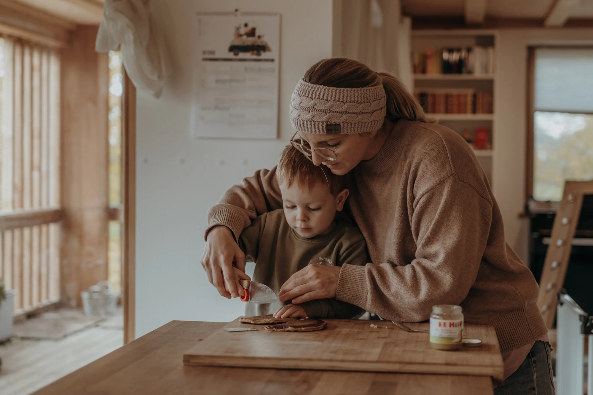 Mama hilft Kind beim Kochen und Schneiden