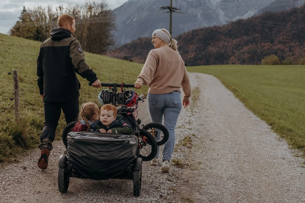 Eltern ziehen Kinder im Bollerwagen