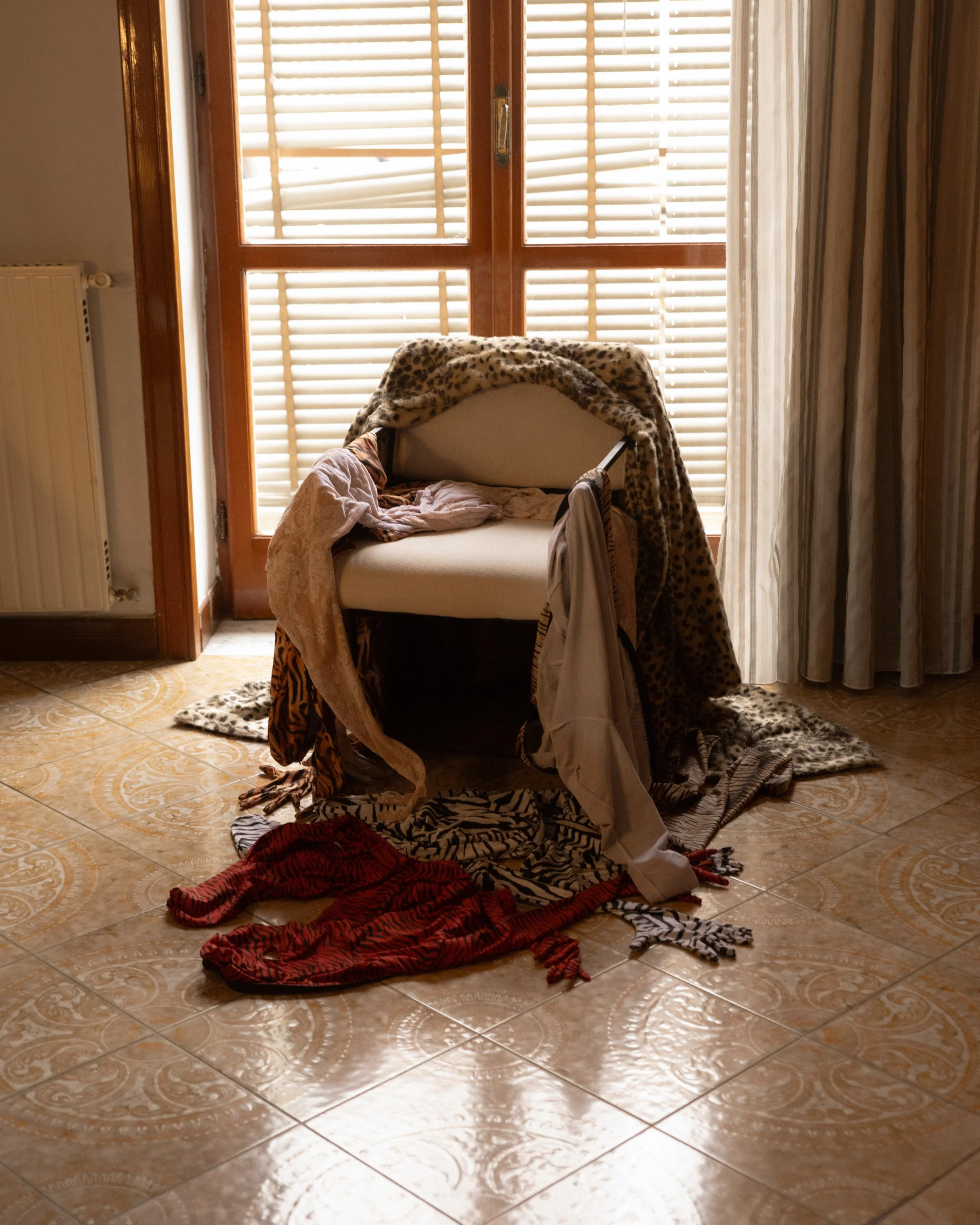 Still life exploring presence, absence, and domestic memory through light and layered fabrics.