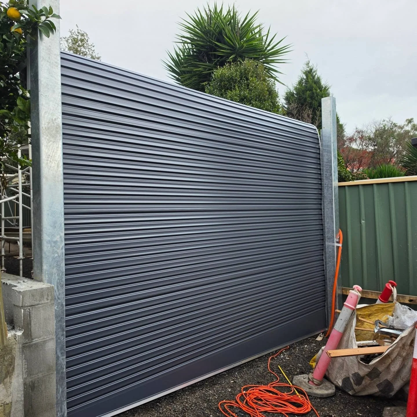Taurean Series AA in Colorbond Ironstone on 125mm galvanised steel posts paired with a Merlin MR555 Weatherdrive.