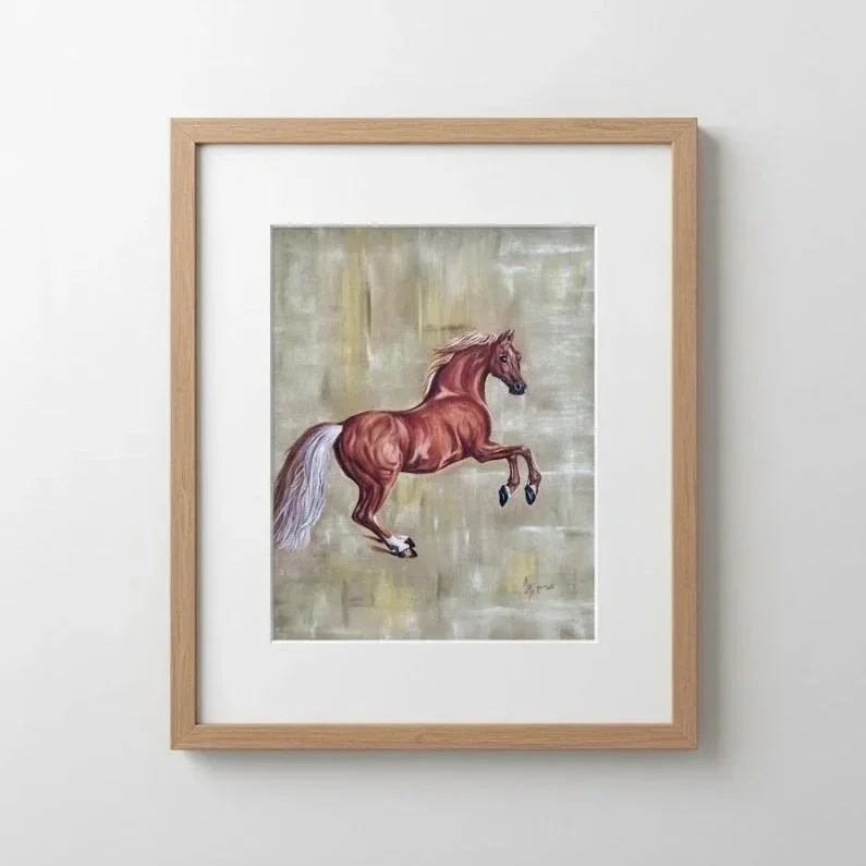 Ein gemaltes Bild eines galoppierenden braunen Pferdes mit weißem Schweif in einem Holzrahmen an einer weißen Wand.