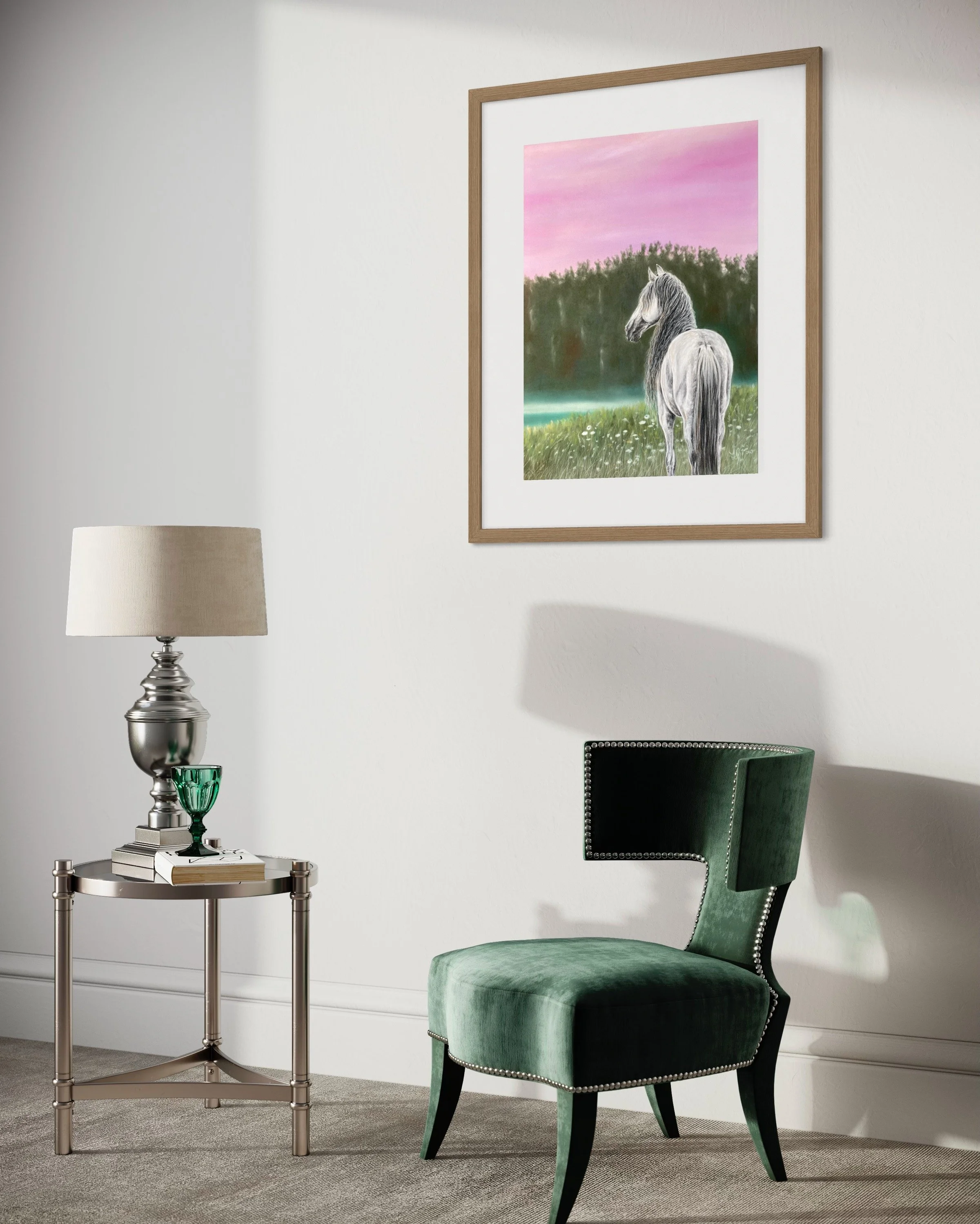 Ein grüner Sessel, eine kleine Beistelltisch auf dem neben eine Tischlampe, eine grüne Glaskuppel und ein Buch liegen, an der weißen Wand hängt ein gerahmtes Bild eines Pferdes mit grauem Fell vor einem pinken Himmel.
