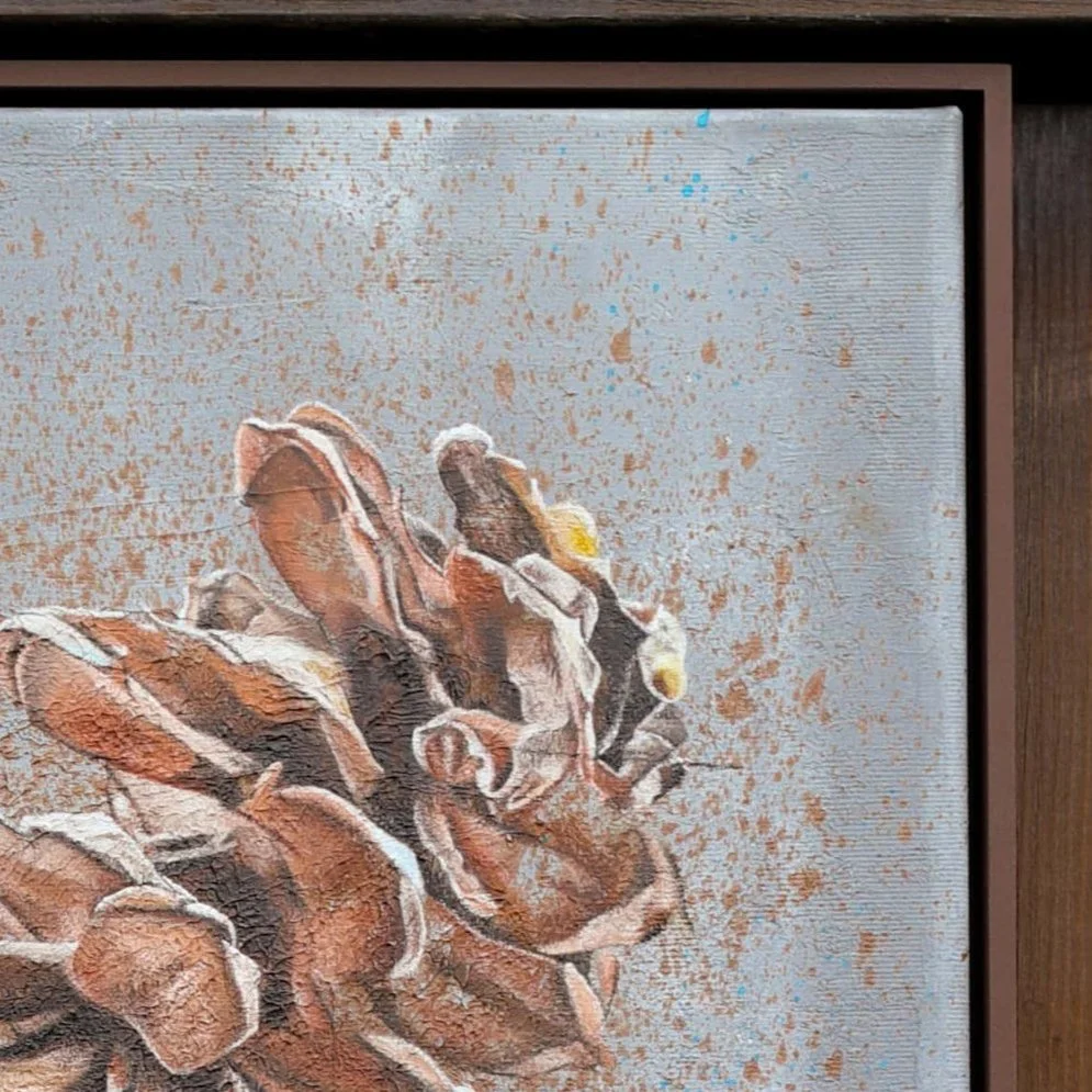 Detail eines gemalten Bildes, das eine Taipeh仙境-Figur mit verschmutztem, braunem und schwarzen Kleid zeigt, auf einem braunen Rahmen, vor einem grauen Hintergrund mit blauen Akzenten.